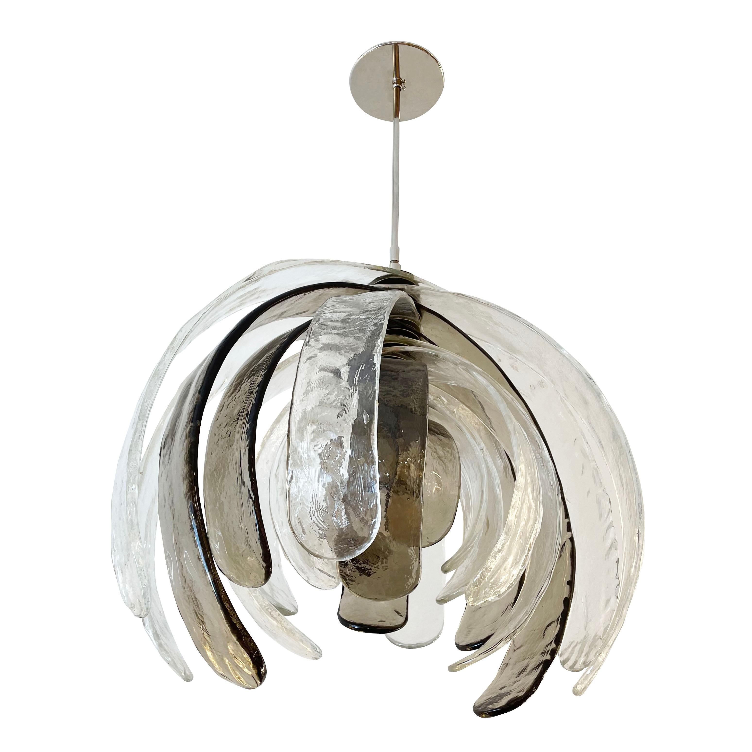 Sculptural Murano glass chandelier designed by Carlo Nason for Mazzega in the 1960s. It’s composed of several alternating clear and gray textured petal shaped glasses that can rotate around the center stem. Polished nickel hardware. Holds one