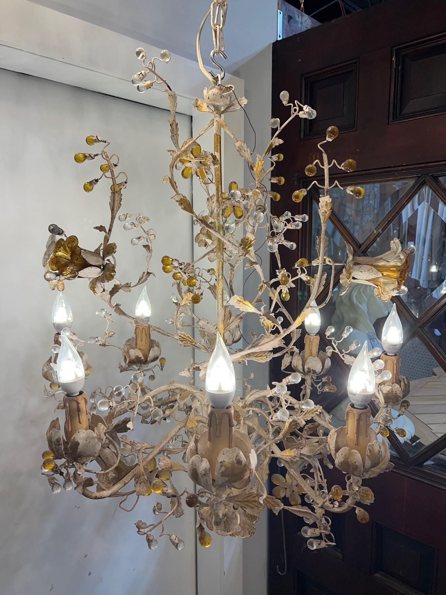 Stunning eight arm, eight light iron chandelier with crystal flowers and crystal bulbs. The iron is a distressed antique white and gold finish with crystal flowers and bulbs. Hand made in Italy in the late 20th century by Articolo Studio, it's in