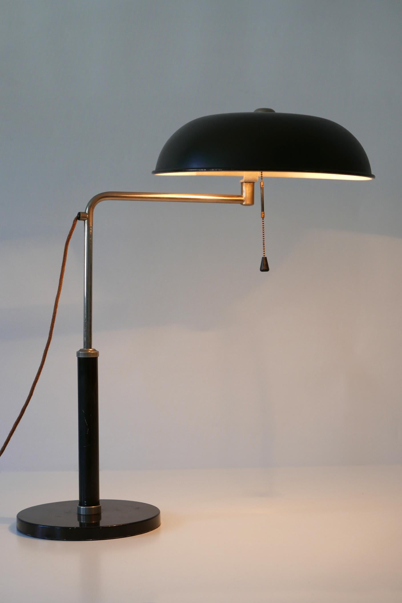 Elegant and adjustable Bauhaus / Art Deco table lamp or desk light. Designed by Alfred Müller for Amba, 1930s, Switzerland.

Executed in dark brown and white enameled aluminium, nickel-plated brass and cast iron, the lamp comes with 1 x E27 / E26