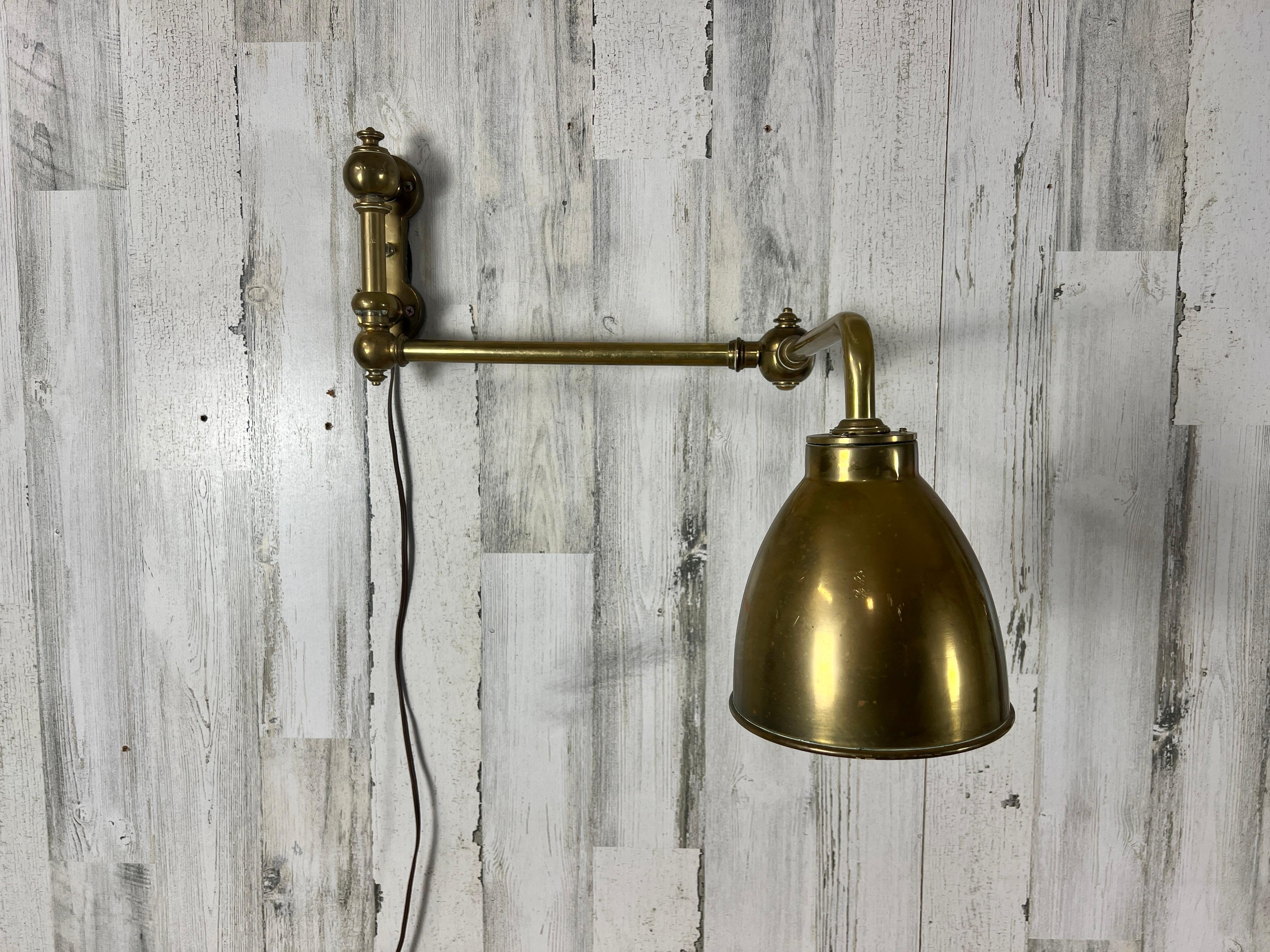 Antique style solid Brass adjustable wall sconce with cone shaped shade.
