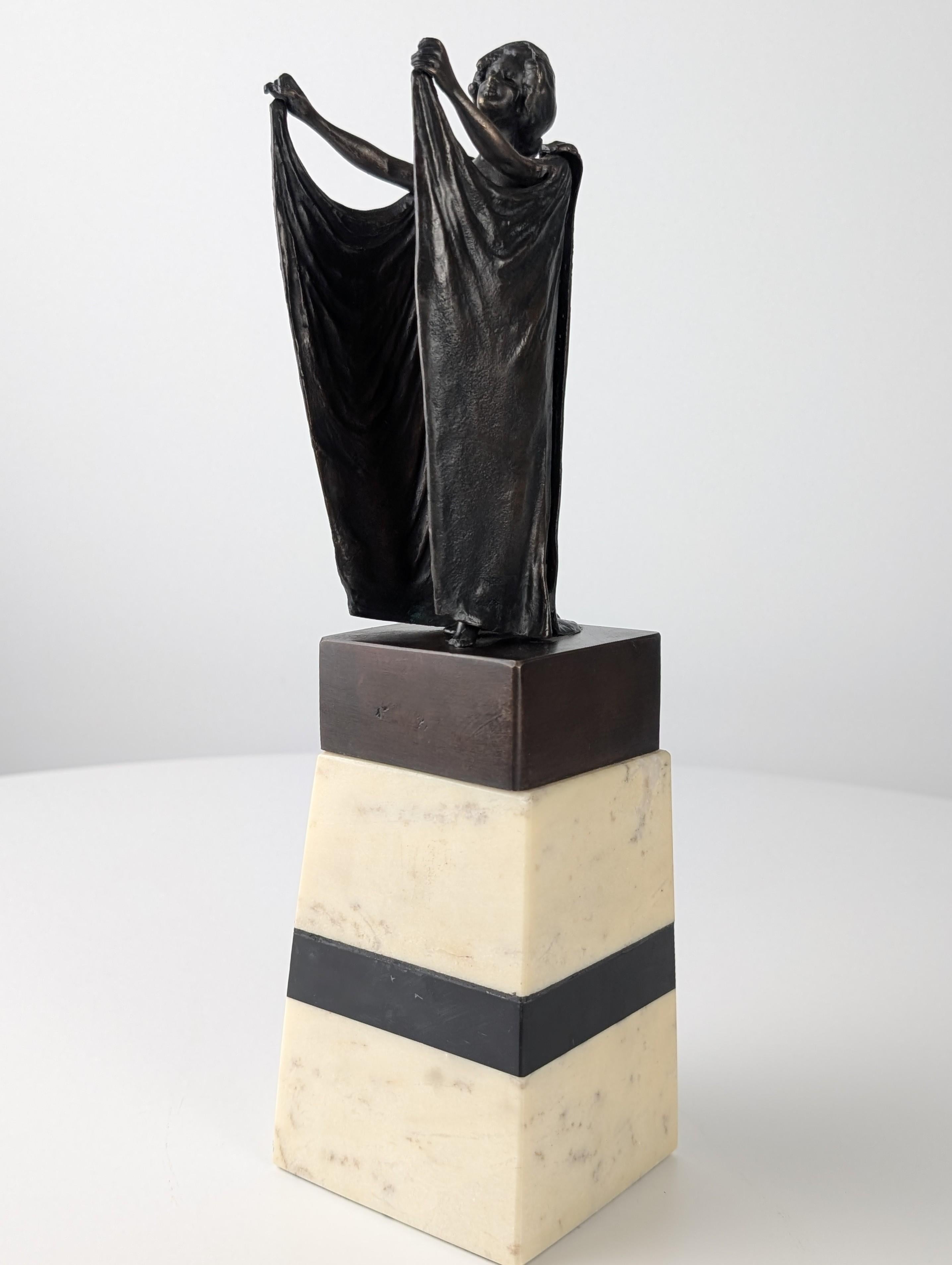 Escultura creada por el célebre escultor austriaco Carl Kauba a principios del siglo XX, que representa una figura femenina en bronce con brazos articulados que pueden revelar u ocultar delicadamente su cuerpo. Esta exquisita pieza encarna la
