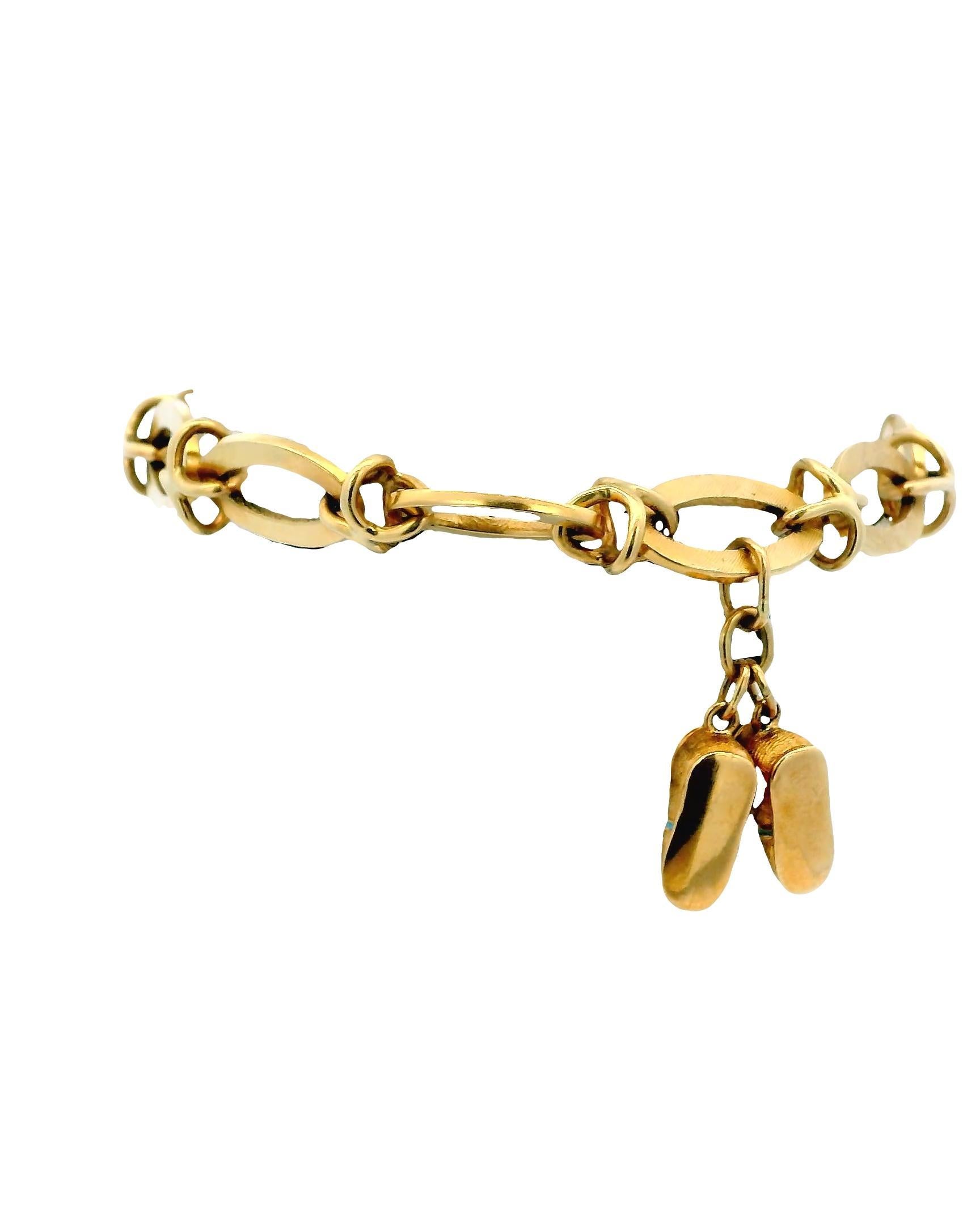 Circa 1960.

This unique bracelet is crafted from 14k gold. It features a series of interlocking oval links. A standout charm in the form of a small, detailed articulated clown figure dangles from the bracelet, adorned with pearl accents.

A large,