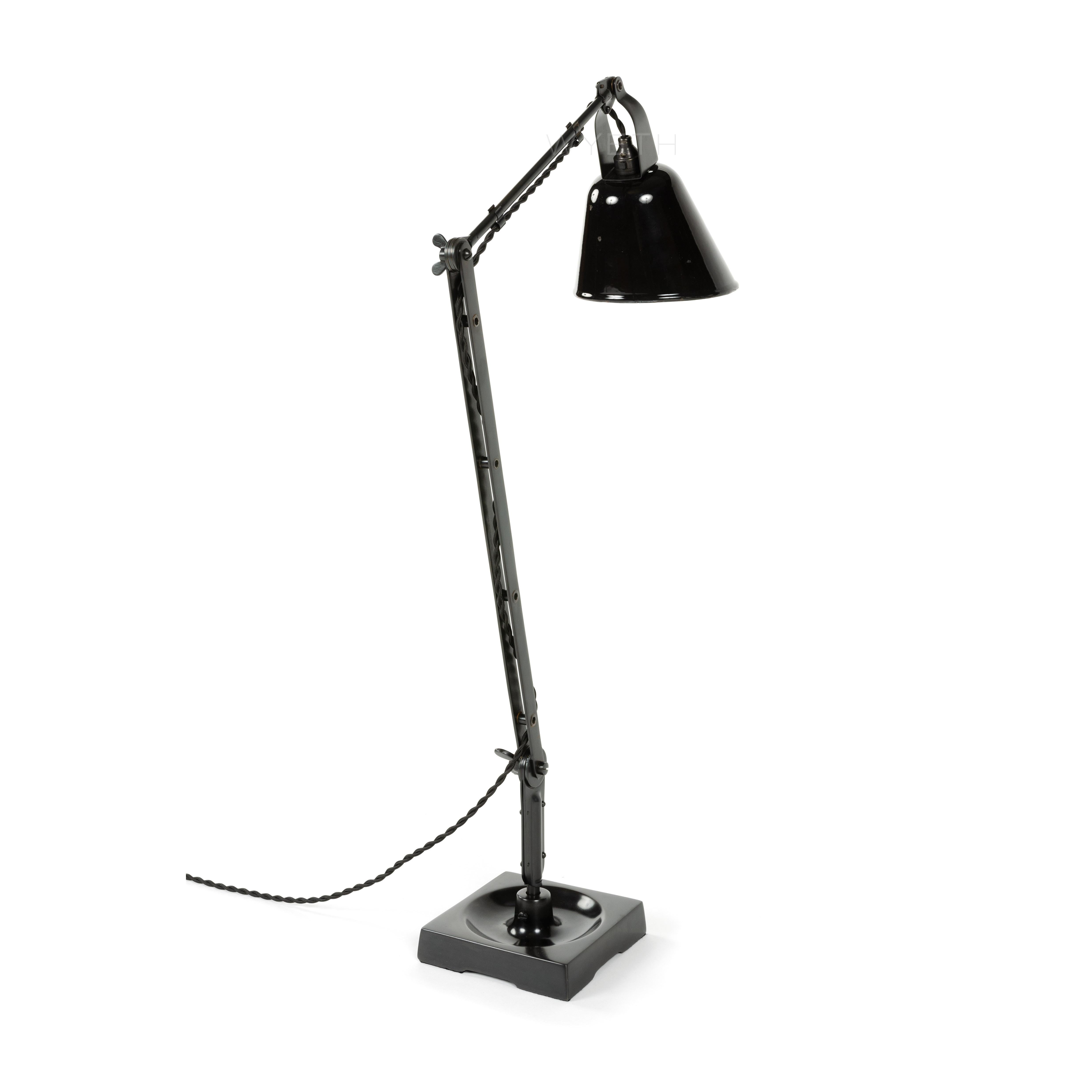 An articulated Zonalite desk lamp with a pivoting black and white enameled shade and a square moat base.