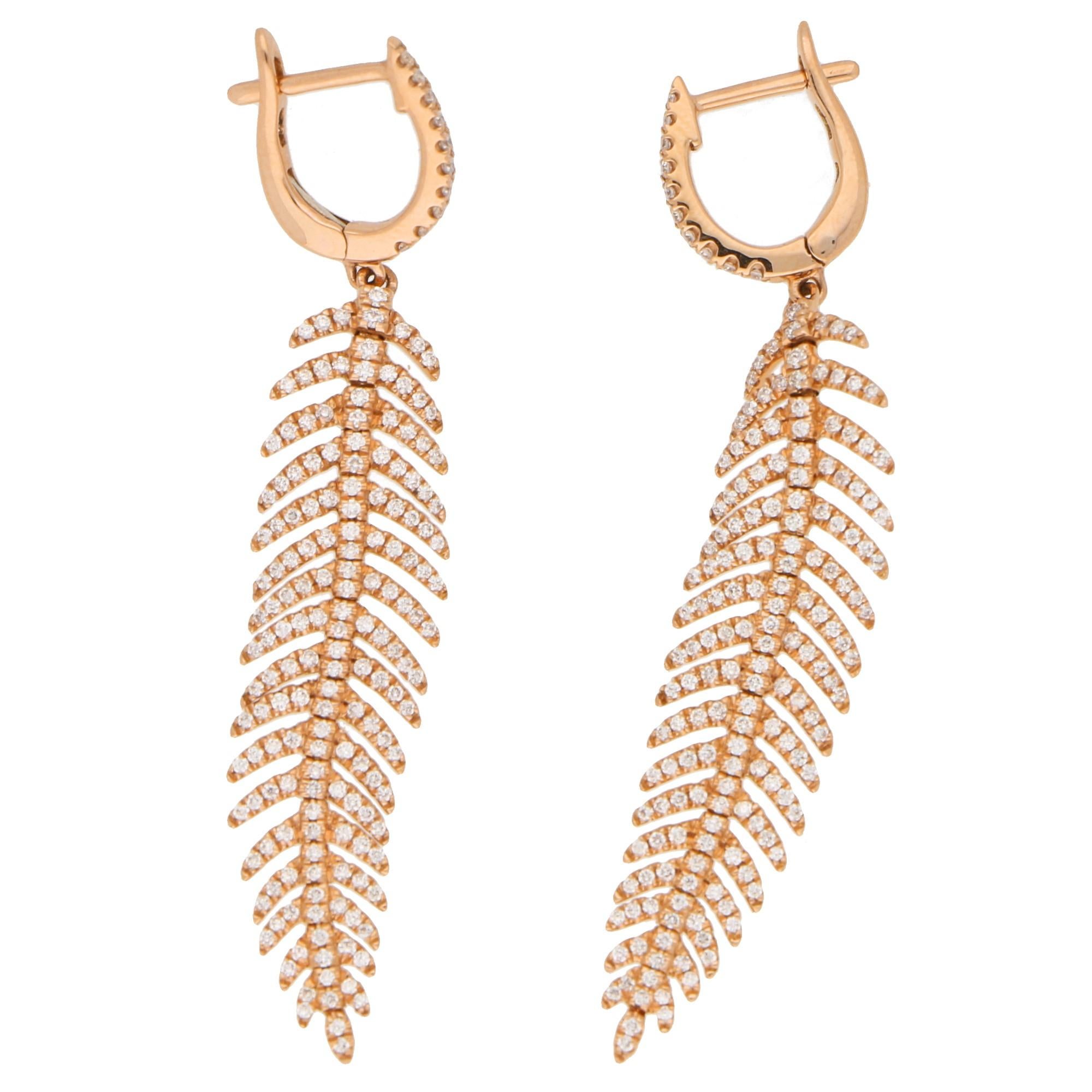 A gorgeous pair of articulated feather diamond drop earrings set in 18k rose gold. 

Each earring depicts a beautiful feather which is articulated and claw-set throughout with round brilliant-cut diamonds. Each feather hangs elegantly from a