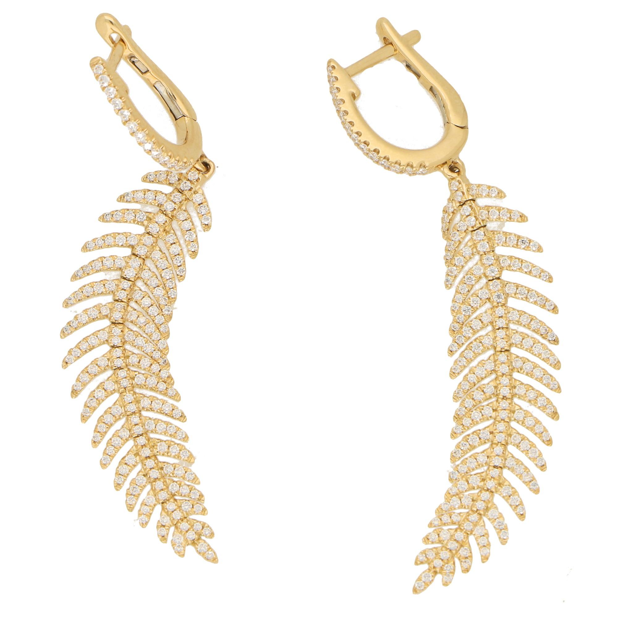 A gorgeous pair of articulated feather diamond drop earrings set in 18k yellow gold. 

Each earring depicts a beautiful feather which is articulated and claw-set throughout with round brilliant-cut diamonds. Each feather hangs elegantly from a
