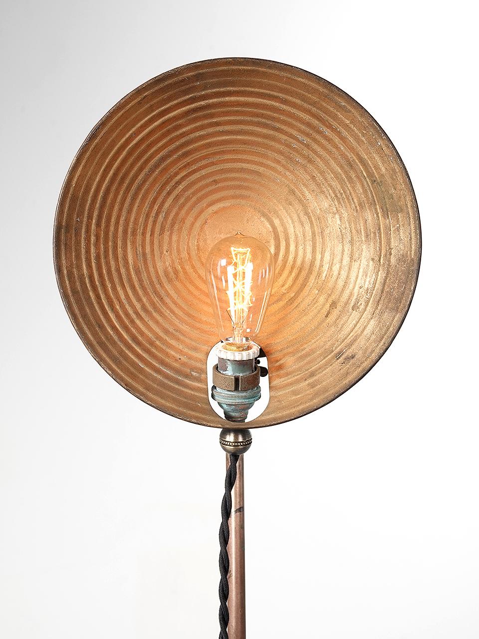 This is a very simple, light and elegant brass and tin floor lamp. Its 1920s Industrial but looks very modern and high style. The tin shade has a stepped ring pattern showing a nice original patina. The stand and base are solid brass.
