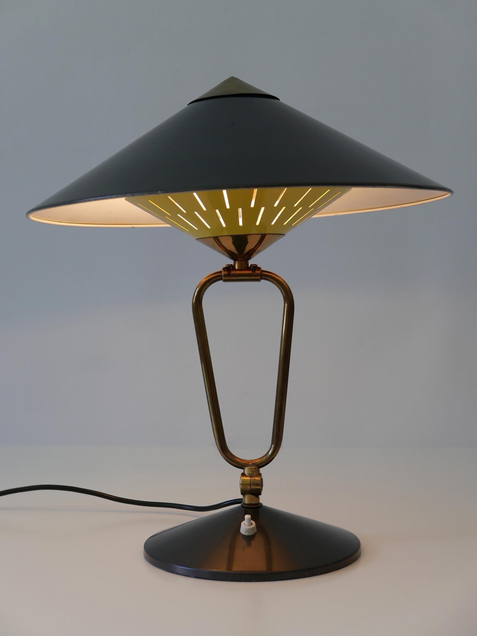 Exceptional, articulated and large Mid-Century Modern table lamp or wall sconce. Designed and manufactured in 1950s, Germany. 
The lamp can be used as table lamp as well as wall sconce. It is adjustable in various ways.

Executed in brass and