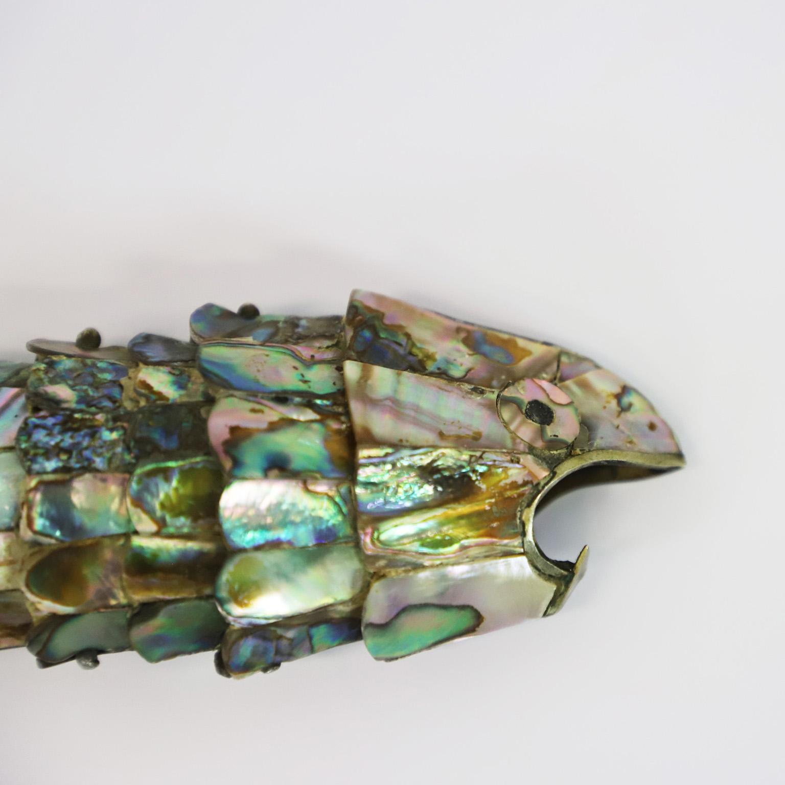 Beautiful vintage Mexican abalone shell and brass bottle opener in the form of fish by Los Castillo.
The mouth of the fish are made of brass which has a very nice aged patina. Made in Taxco Mexico, circa 1960s, stamped by Los Castillo.