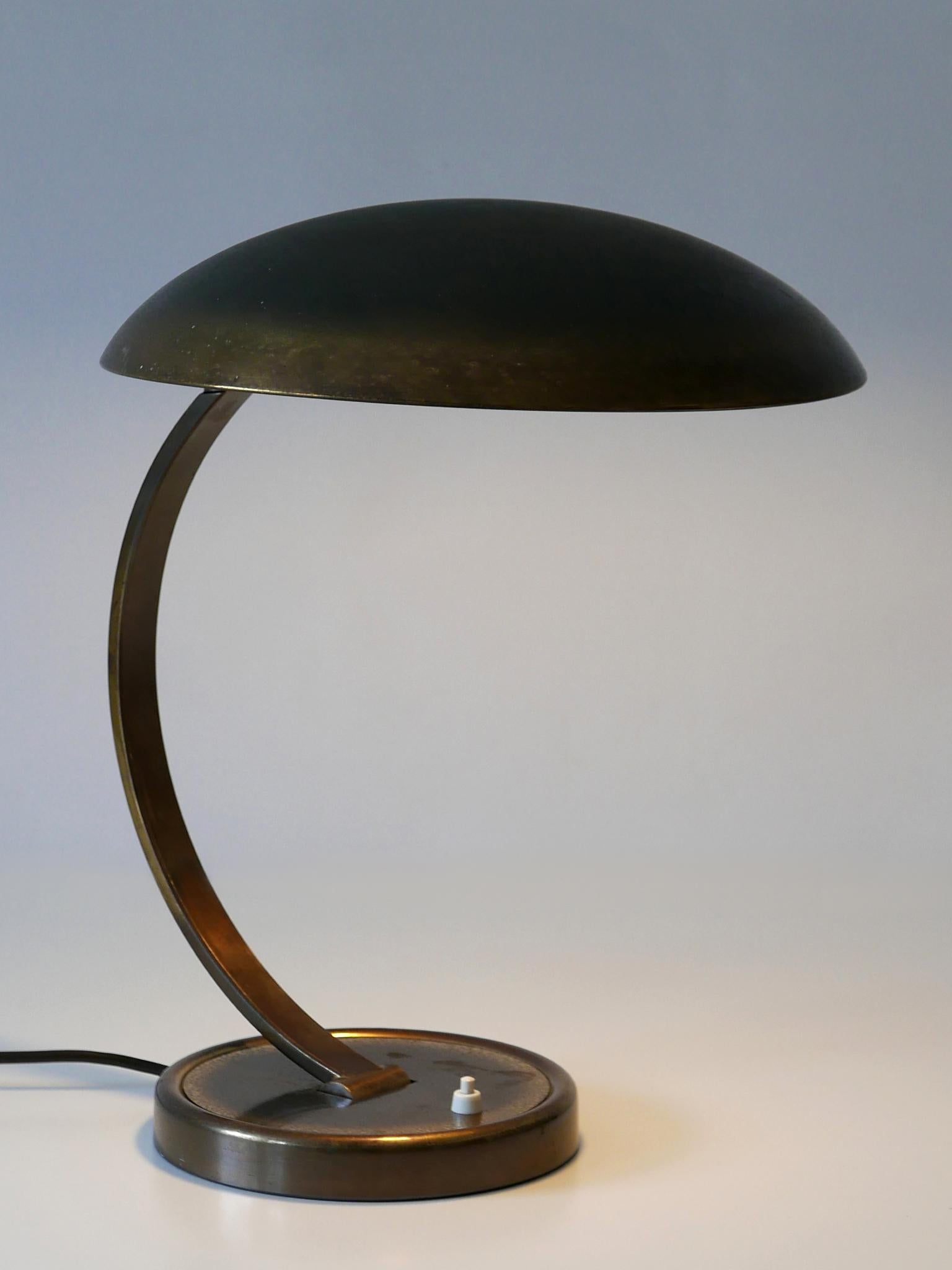 Elegant, articulated desk light or table lamp. Model 6751. Adjustable and rotating arms and shades. Designed by Christian Dell for Kaiser Idell, 1950s, Germany.

Executed in patinated brass, the lamp needs 1 x E27 / E26 Edison screw fit bulb, is