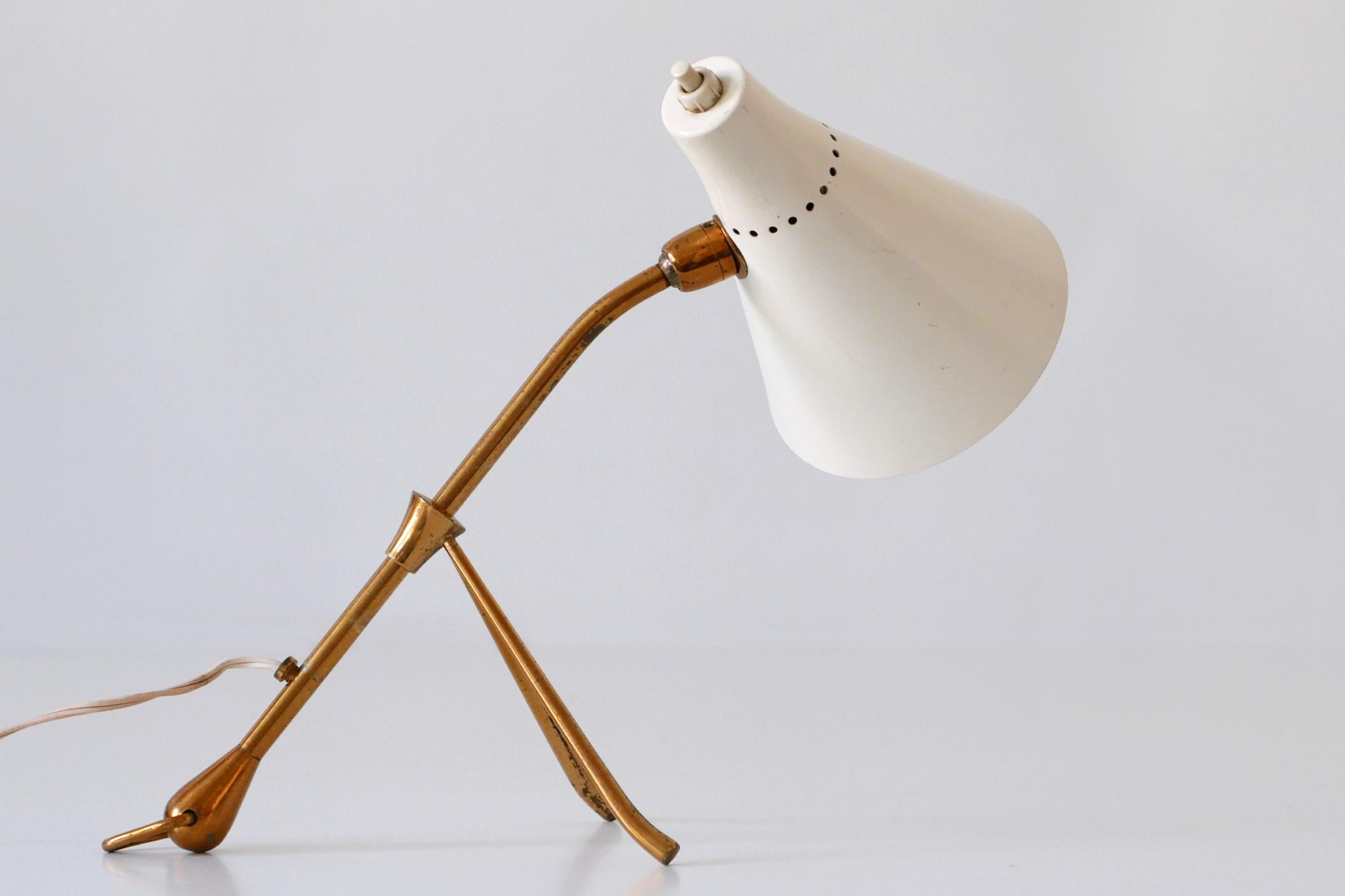 Lovely Mid-Century Modern table or wall lamp. Designed by Giuseppe Ostuni for Oluce, 1950s, Italy. The table lamp can be used as well as a wall lamp. The lamp shade and arm are adjustable in various position.

Executed in white enameled aluminium