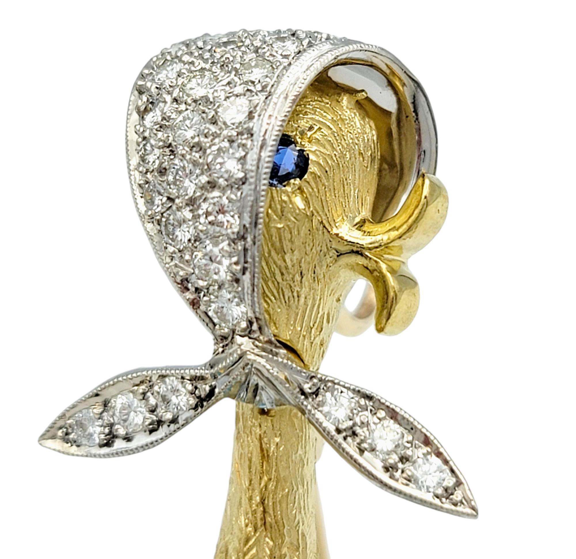 Step into a world of whimsy and elegance with this enchanting brooch that doubles as a pendant, a true testament to creativity and fine craftsmanship. Crafted in a luxurious blend of 18 karat yellow and white gold, this piece features the beloved
