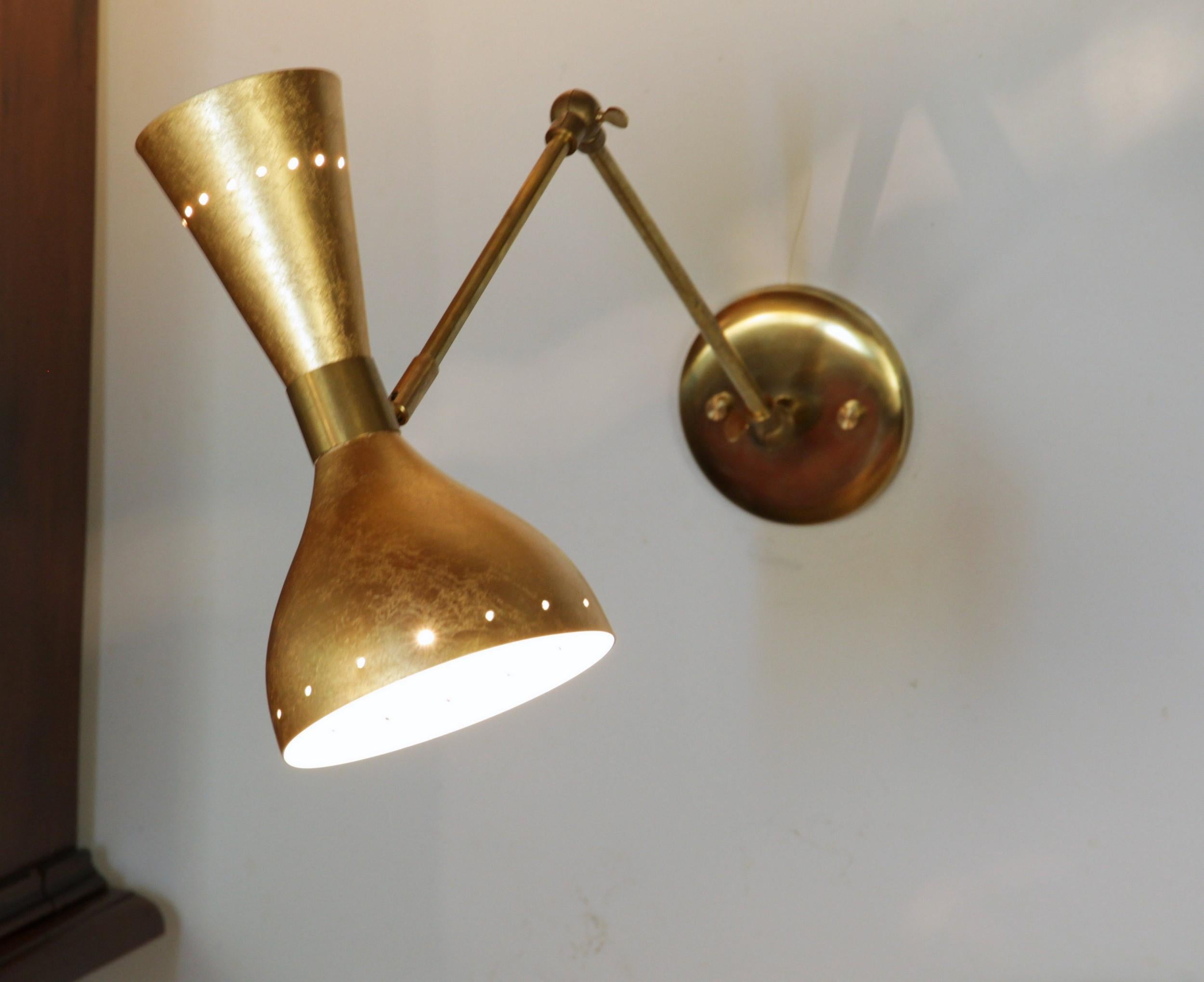Thanks to a customer who wanted this finish, combining a typical renaissance Tuscan gold leaf finish with a Mid-Century Modern shape.

This beautiful sconce has three moving joints.
On the backplate and the middle you have a dented joint for