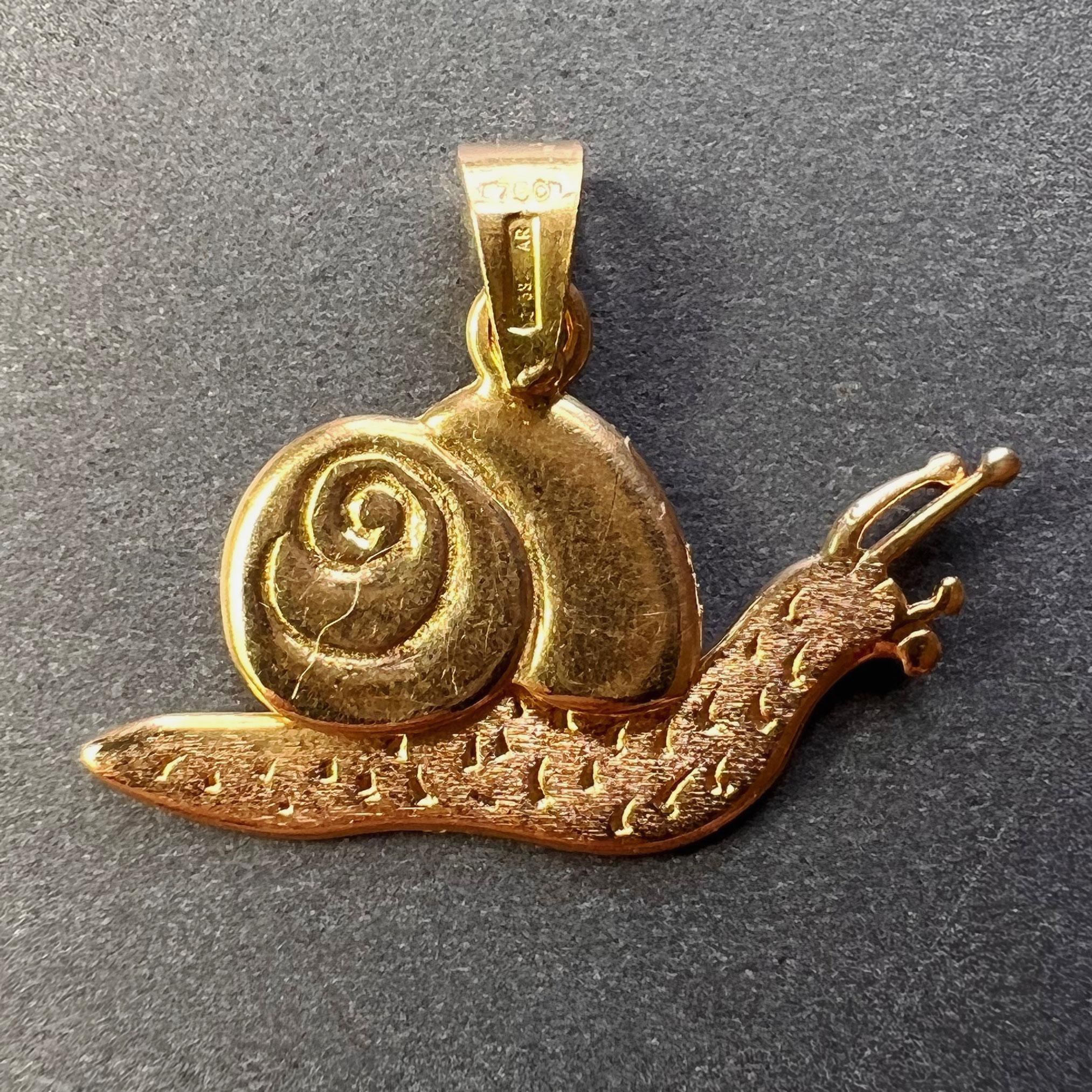 An 18 karat (18K) yellow gold charm pendant designed as an articulated snail with a hinged shell and body. Stamped 750 for 18 karat gold and 38AR for Italian manufacture to the bail.
 
Dimensions: 1.5 x 2.5 x 0.2 cm (not including jump ring)
Weight: