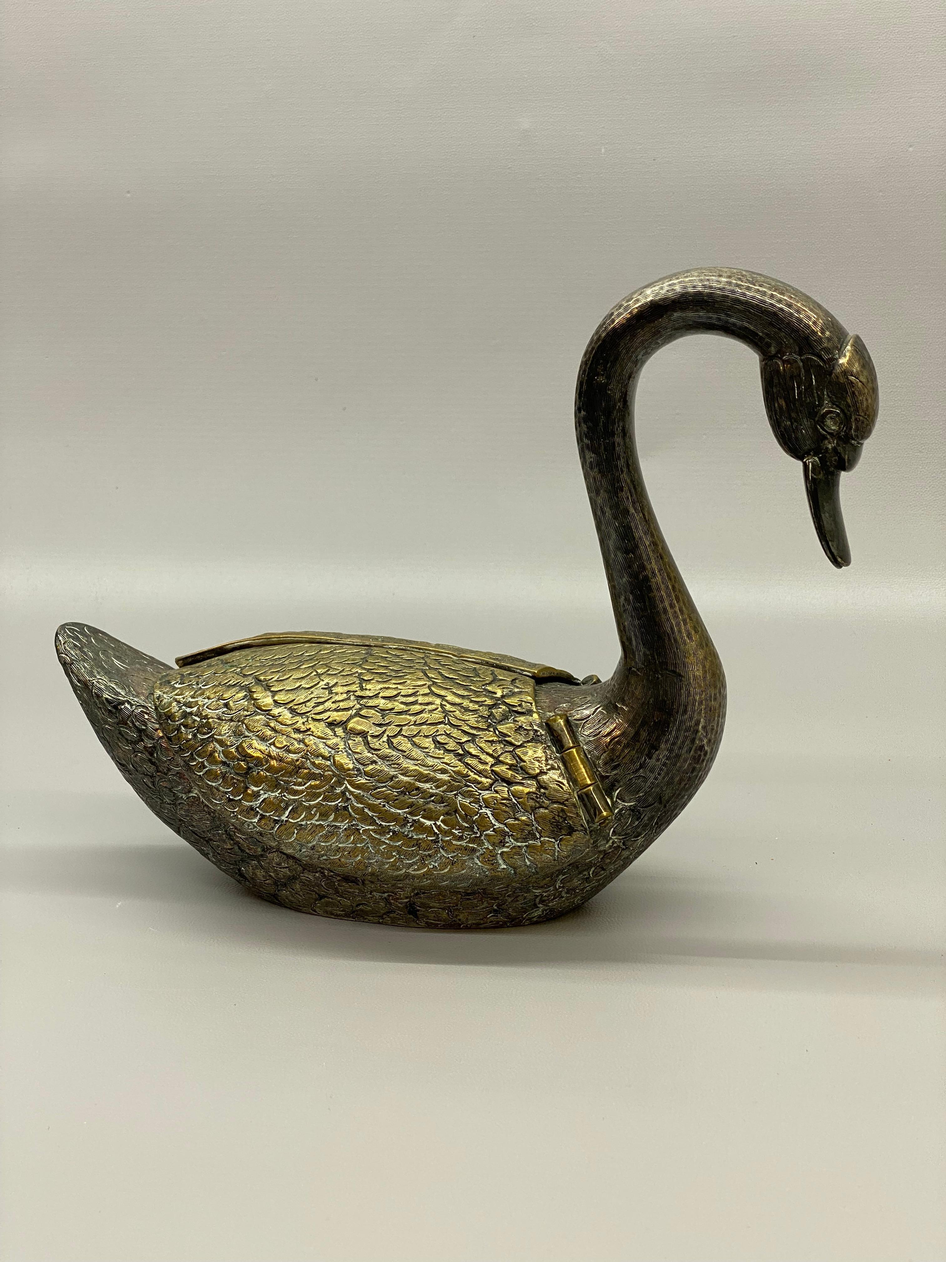 Se vende cisne de latón fundido plateado con alas articuladas. Cuando se levantan las alas, queda al descubierto una copa interior de forma ovalada. La taza es extraíble. Detalles finamente moldeados, desde las plumas hasta el manejo del cuello, los