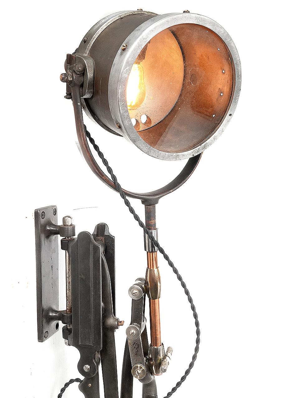 This is an early and complex articulated arm fitted with a wood handled reflector spot light. The combination has just the right look.It is signed on a brass plaque and reads...Rapid Fire Torpedo Type Searchlight... Miller Mfg., Peekskill NY. The