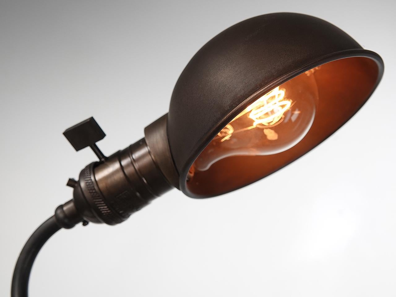 The look of this four foot long articulated lamp is totally unique. The base is a solid tripod casting with a lockable fitting. The arm has a question mark style curved pipe that rides in the fitting to raise and lower the lamp. There is a second