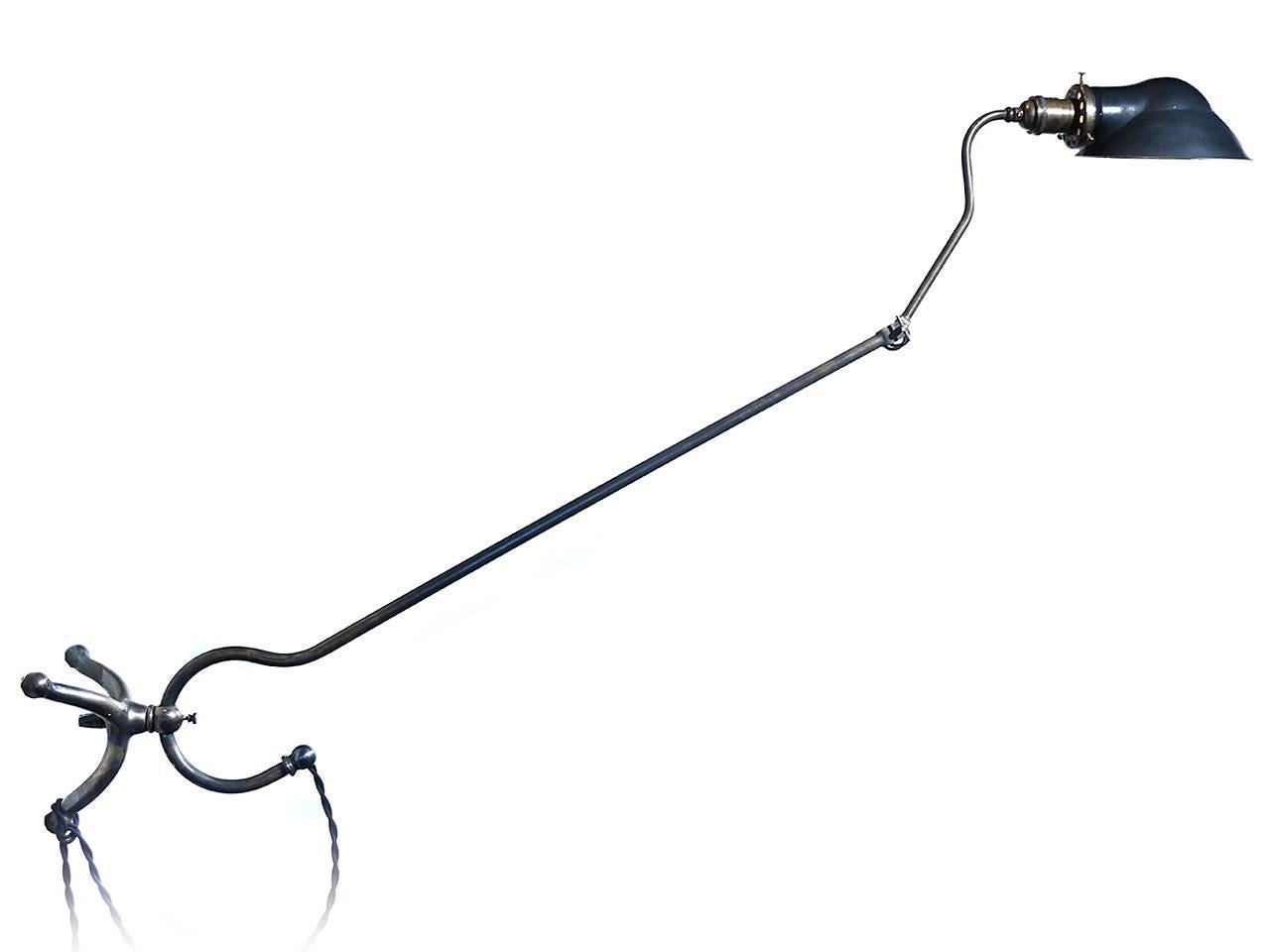 The look of this four foot long articulated lamp is totally unique. The base is a solid tripod casting with a lockable fitting. The arm has a question mark style curved pipe that rides in the fitting to raise and lower the lamp. There is a second