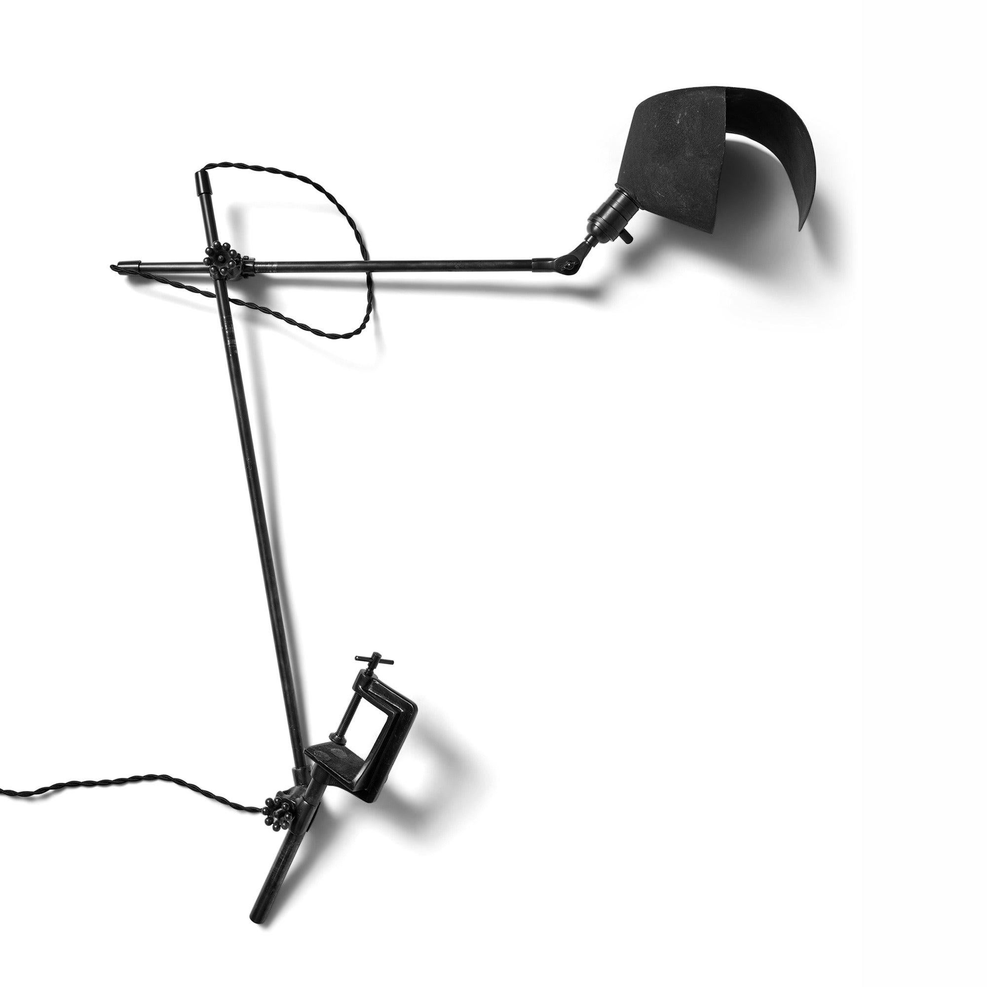 Lampe de bureau ou de table en acier avec une base à pince et un bras réglable supportant un abat-jour unique.