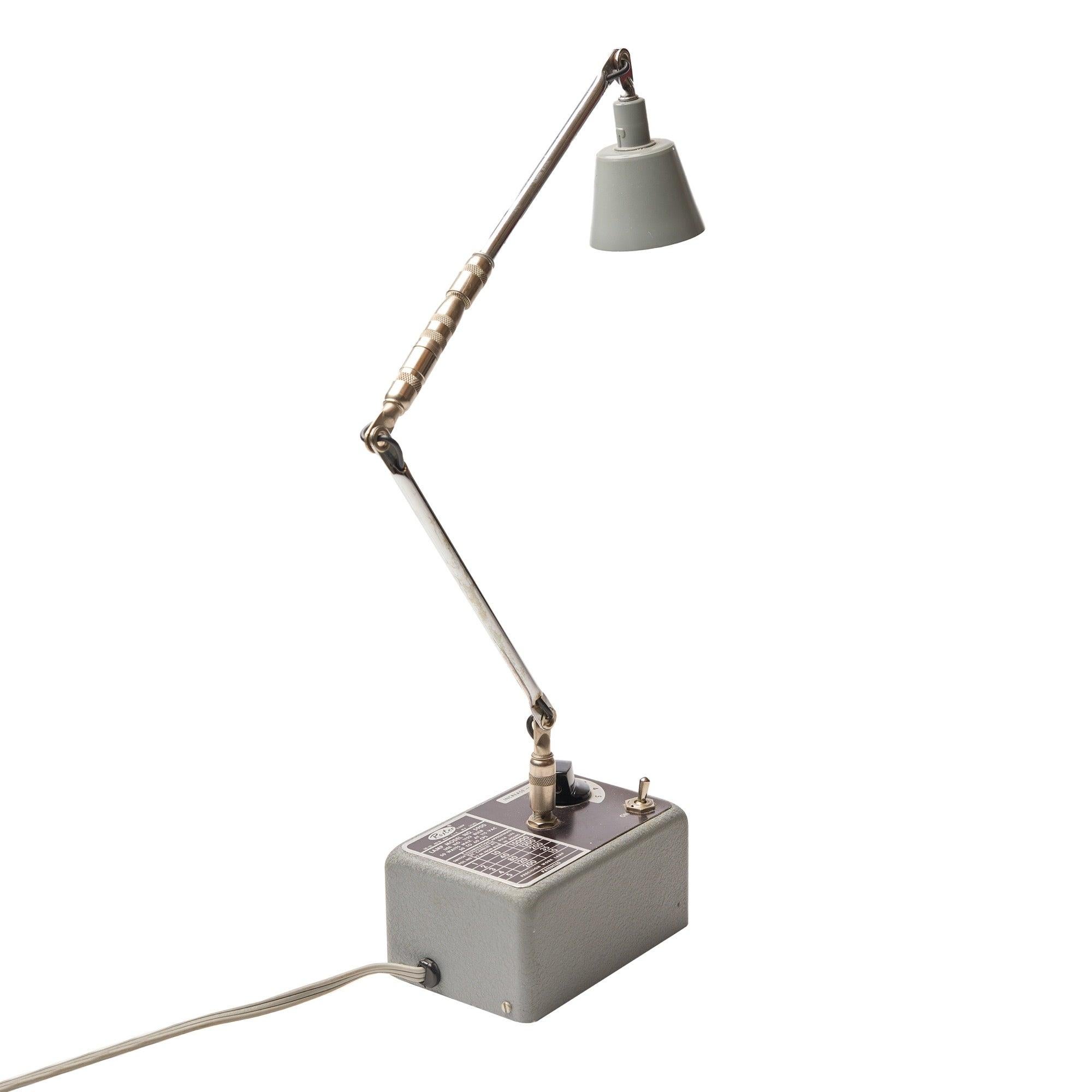 A petite desk lamp with articulating arm and painted shade and base in grey.