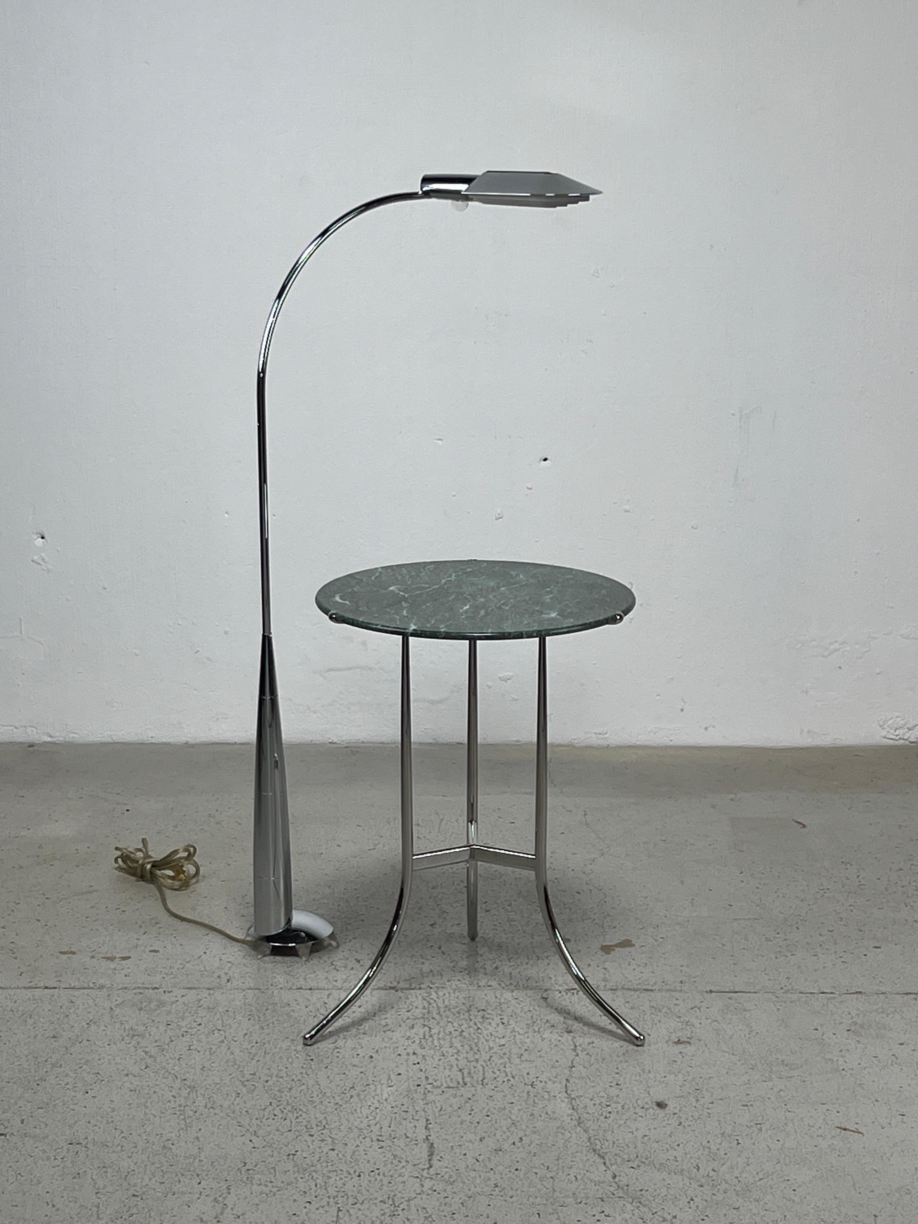 A chrome floor lamp with rotating base and swiveling head by Cedric Hartman. 