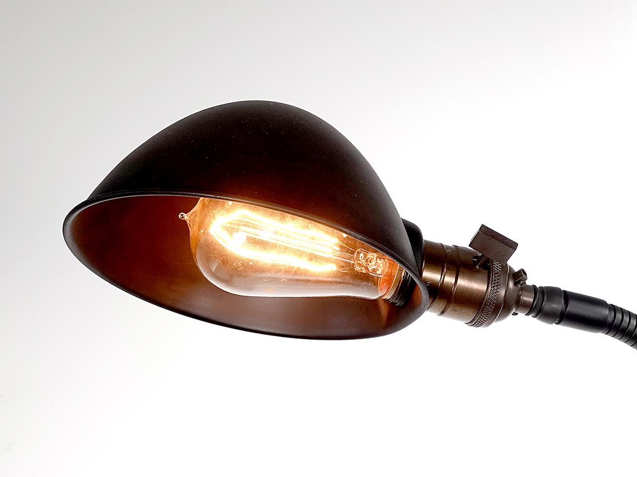 This is a nicely designed example of a Pharmacy style lamp. The base is heavy with an 9 inch diameter. The vertical stand is topped with an easy to use gooseneck for articulating the shade. The brass shade is a half dome and the E26 socket. The