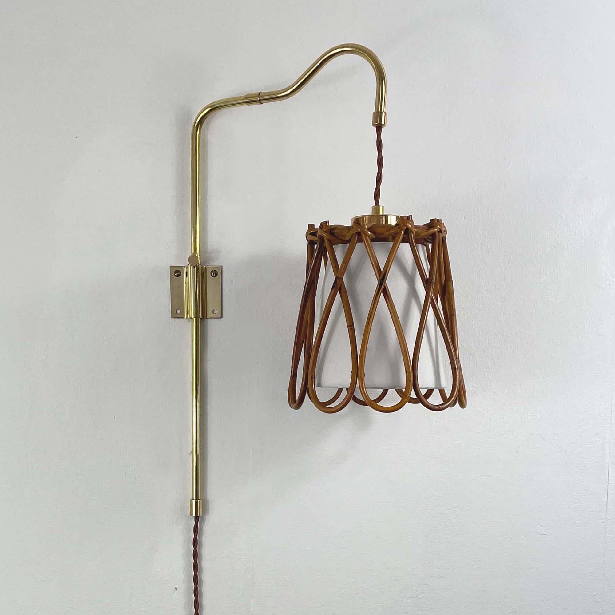 Questa lampada da parete di metà secolo è stata progettata e prodotta in Francia negli anni '50. 

La lampada è montata su una staffa da parete in ottone con un braccio articolato che può essere regolato sia in verticale che in orizzontale. Il