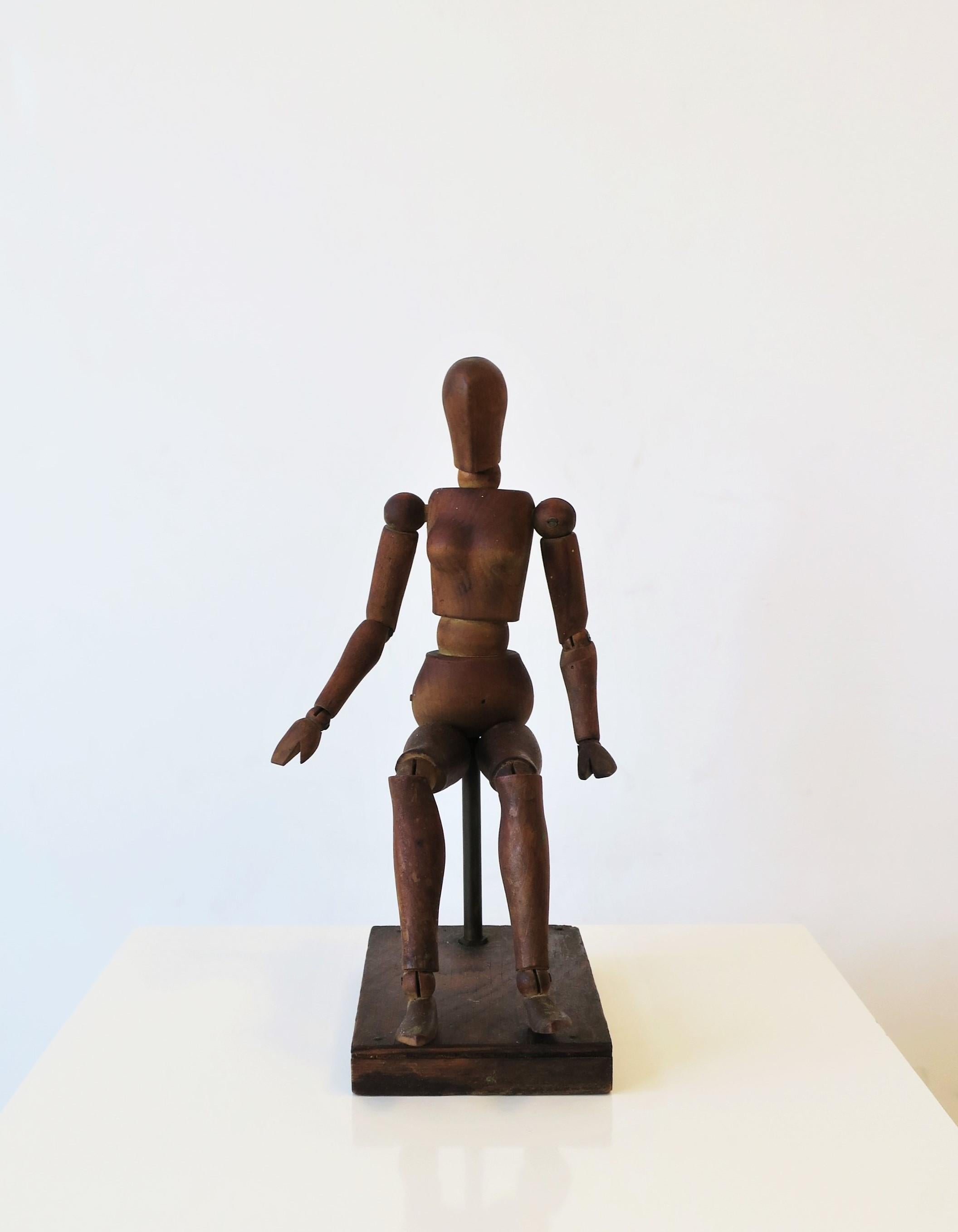 A seated vintage articulating artist wood model female figure sculpture piece with stand, circa early to mid-20th century. Dimensions including wood base: 4.94