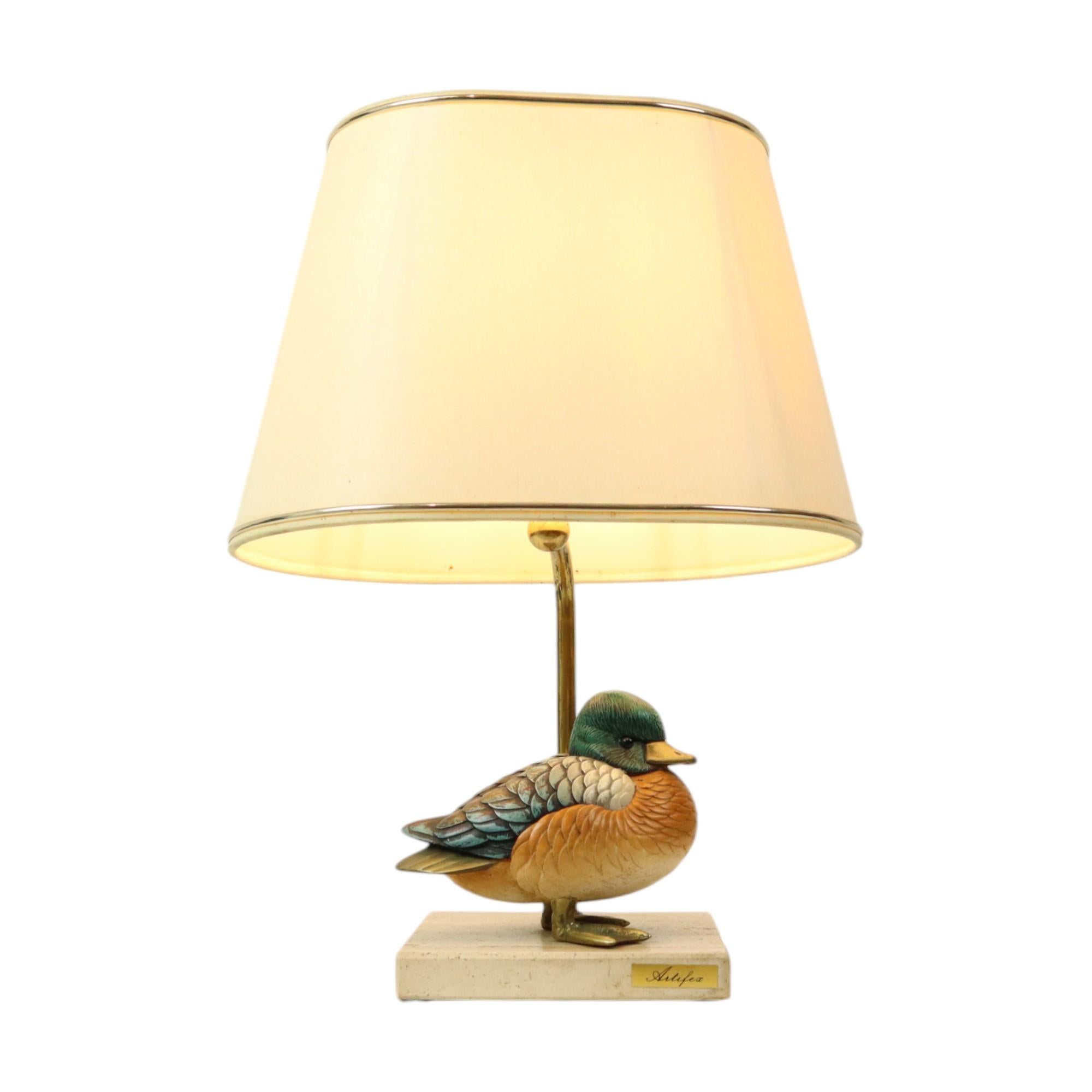 Vintage duck design lamp by Elli Malevolti for Artiflex, circa 1970s, marked on the bottom; the duck is also signed at the bottom of the tail.

The duck is made of cast resin and brass, mounted on a square travertine base, with a brass stem and a