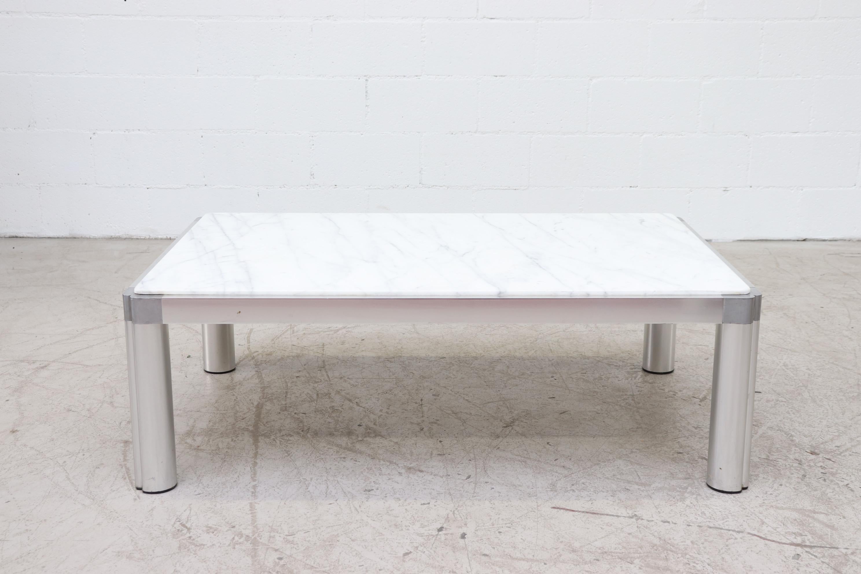 1970s modern Artifort M100 coffee table by Kho Liang Ie. The base (leg and beam) are of extruded, anodized aluminum, connected by corner elements in polished cast iron, with plastic glides and inset marble top. 