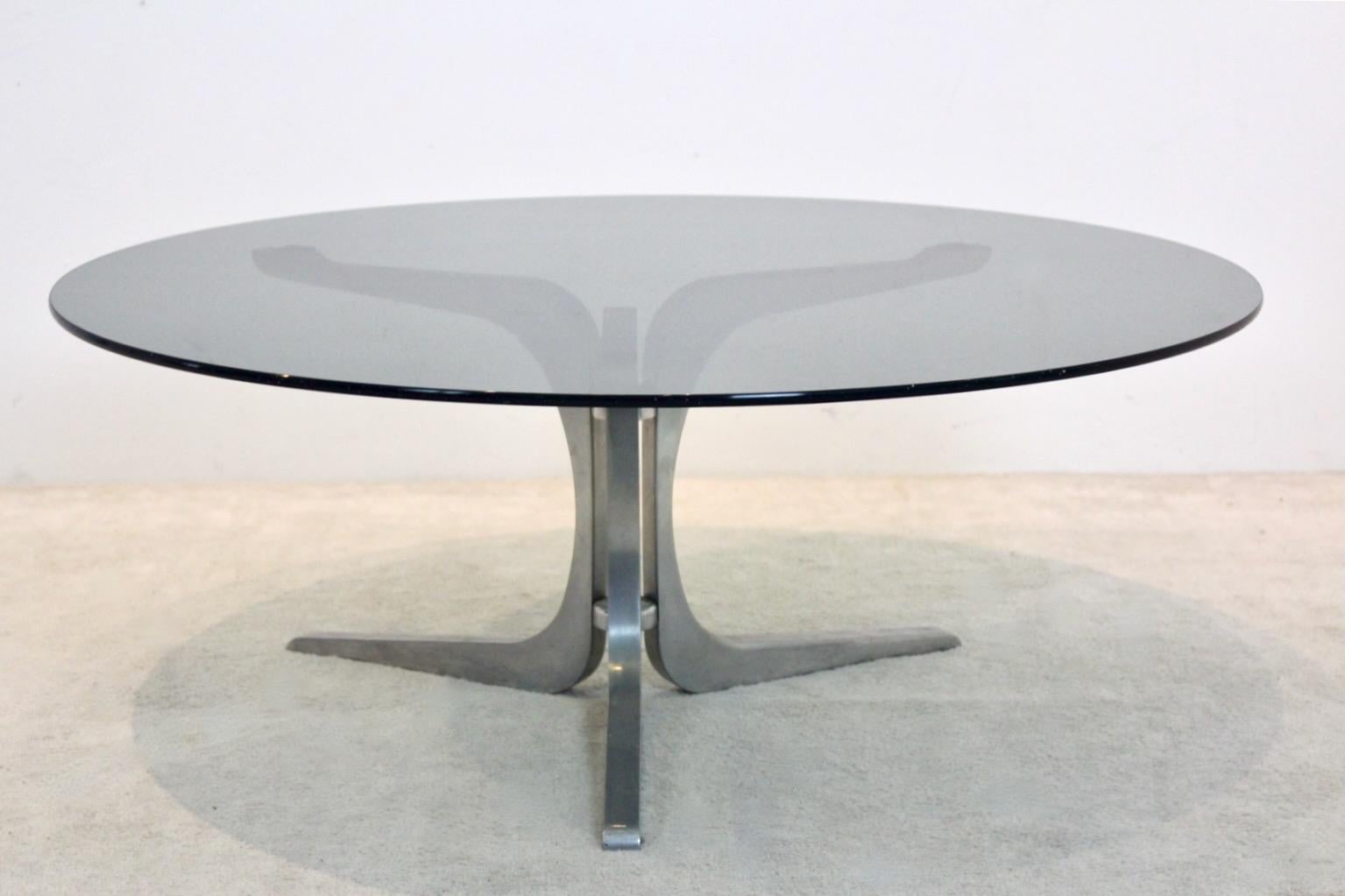 Sophisticated and original Round Coffee table designed by Geoffrey Harcourt for Artifort furniture in the Netherlands. With a smoked glass top and aluminum base with sculptural structure. Normal wear due to age and use, however in good condition. A