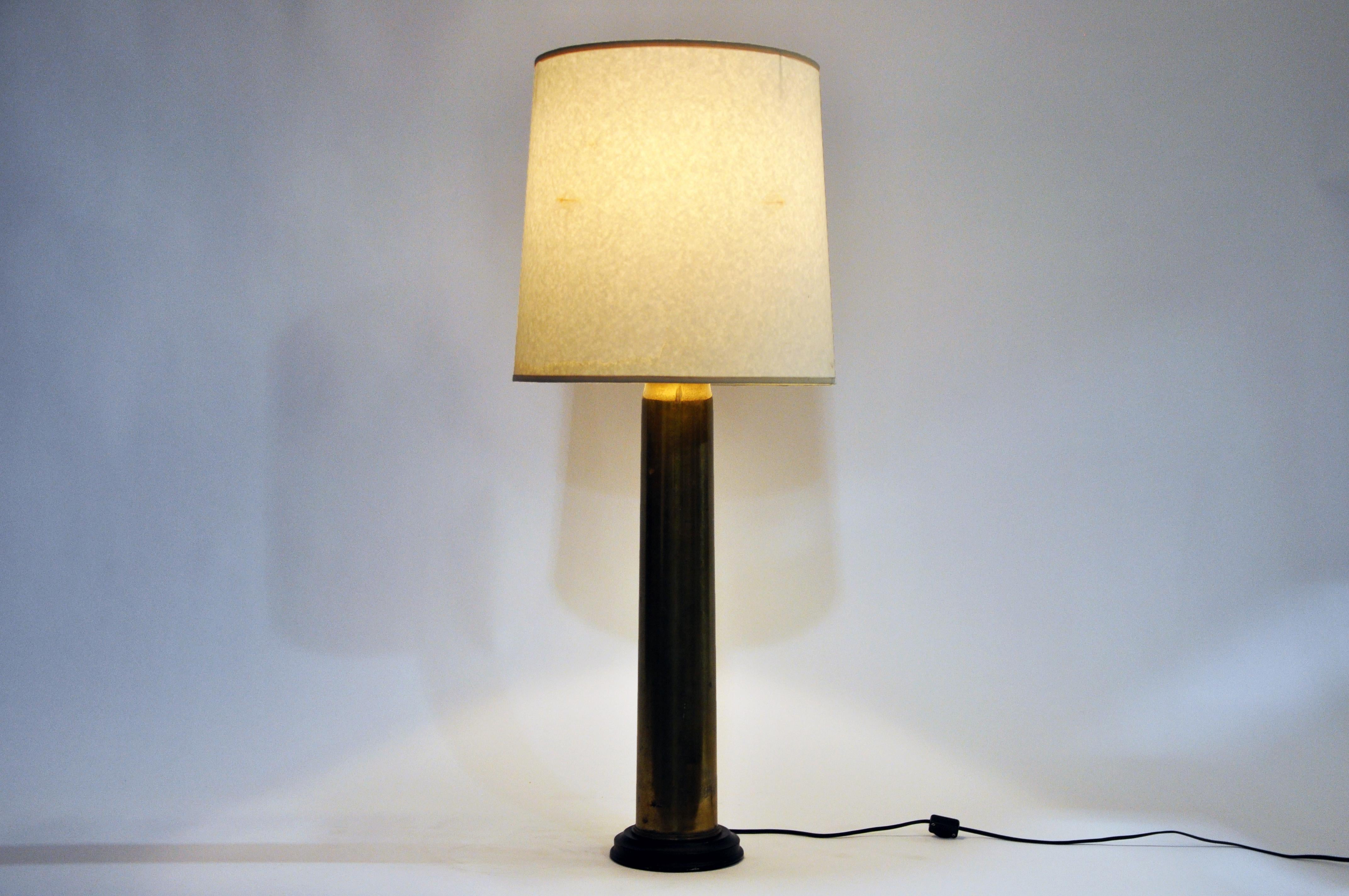 This WWI era brass shell casing has been made into a lamp. The lamp features a cream shade, a 3-way socket, and a cord switch.
     
