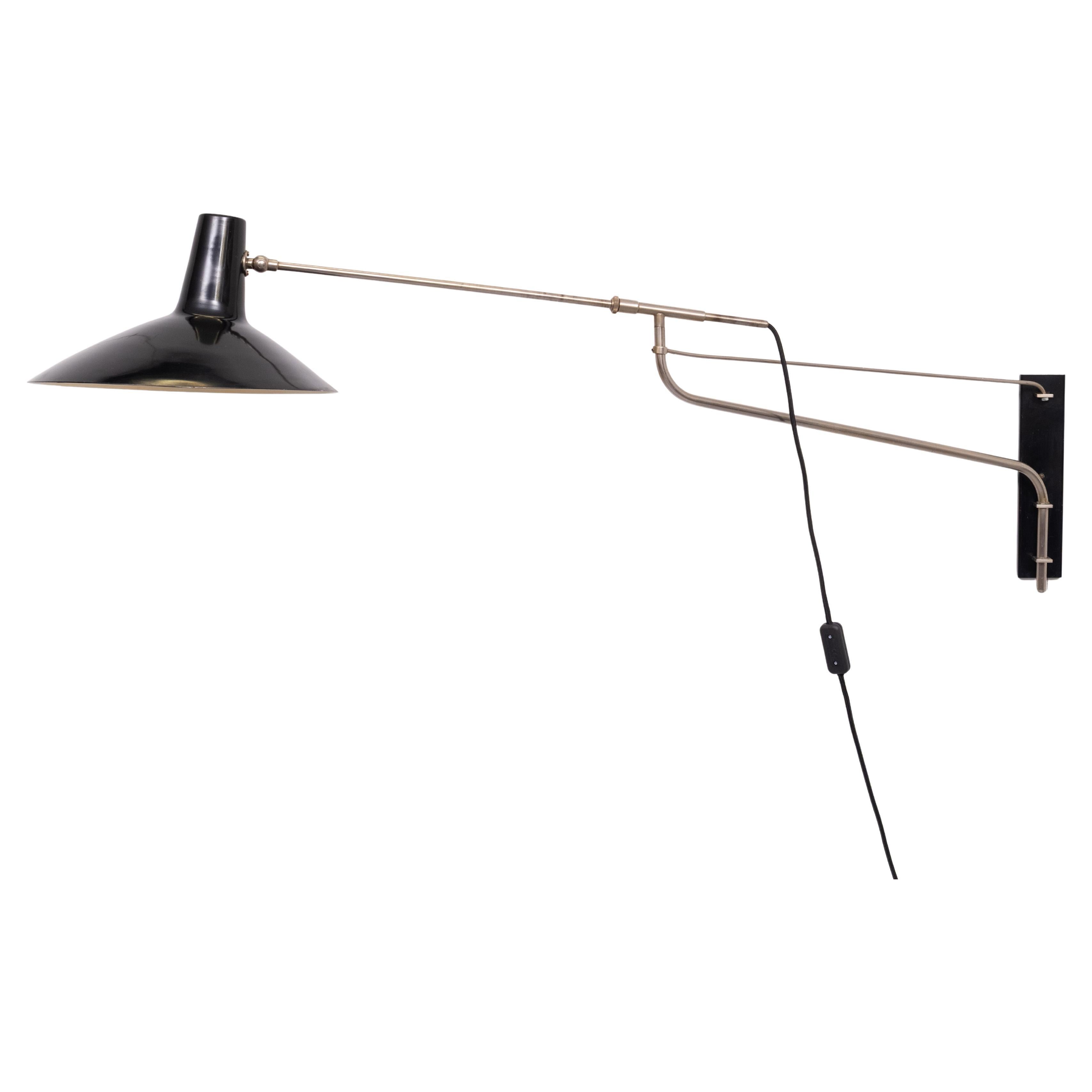 Qui è stata offerta una fantastica lampada a braccio oscillante nera e nichel degli anni Cinquanta. Le dimensioni sono piuttosto grandi; quando è completamente estesa, la luce ha una profondità di 130 cm dalla parete. I tratti distintivi tipici