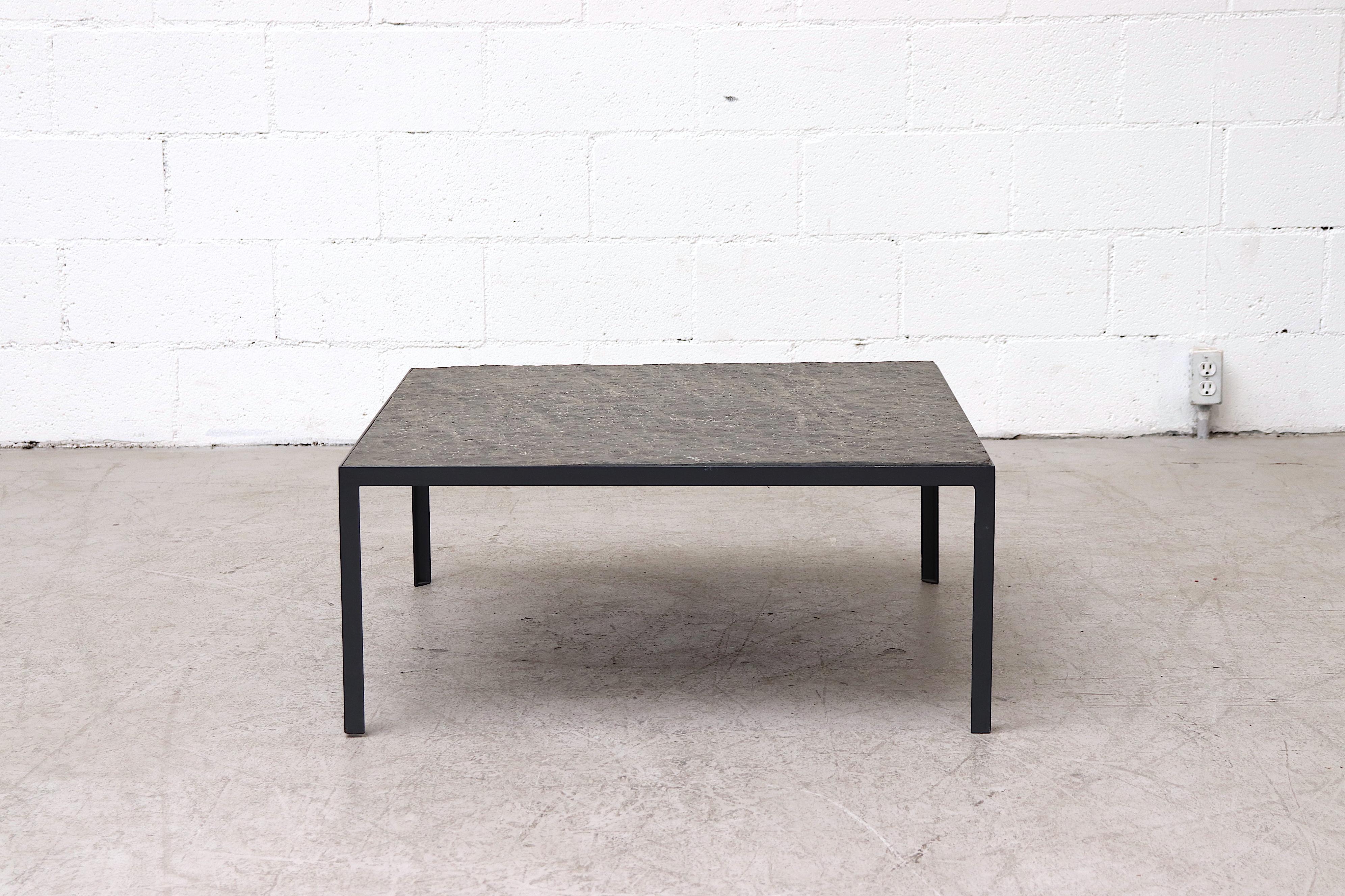 Incredible square coffee table with inset textured stone top and grey enameled metal frame. In original condition with minimal visible wear to top and frame.