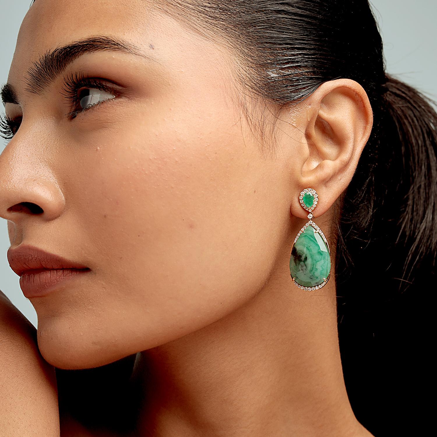 These luxurious drop earrings by Artisan feature a total of 28.55ct pear-shaped emeralds accented with halos of 0.98ct round diamonds, all set in 7.766g of 18K yellow gold. Measuring 45x18mm, their impressive silhouette and vivid color make for a