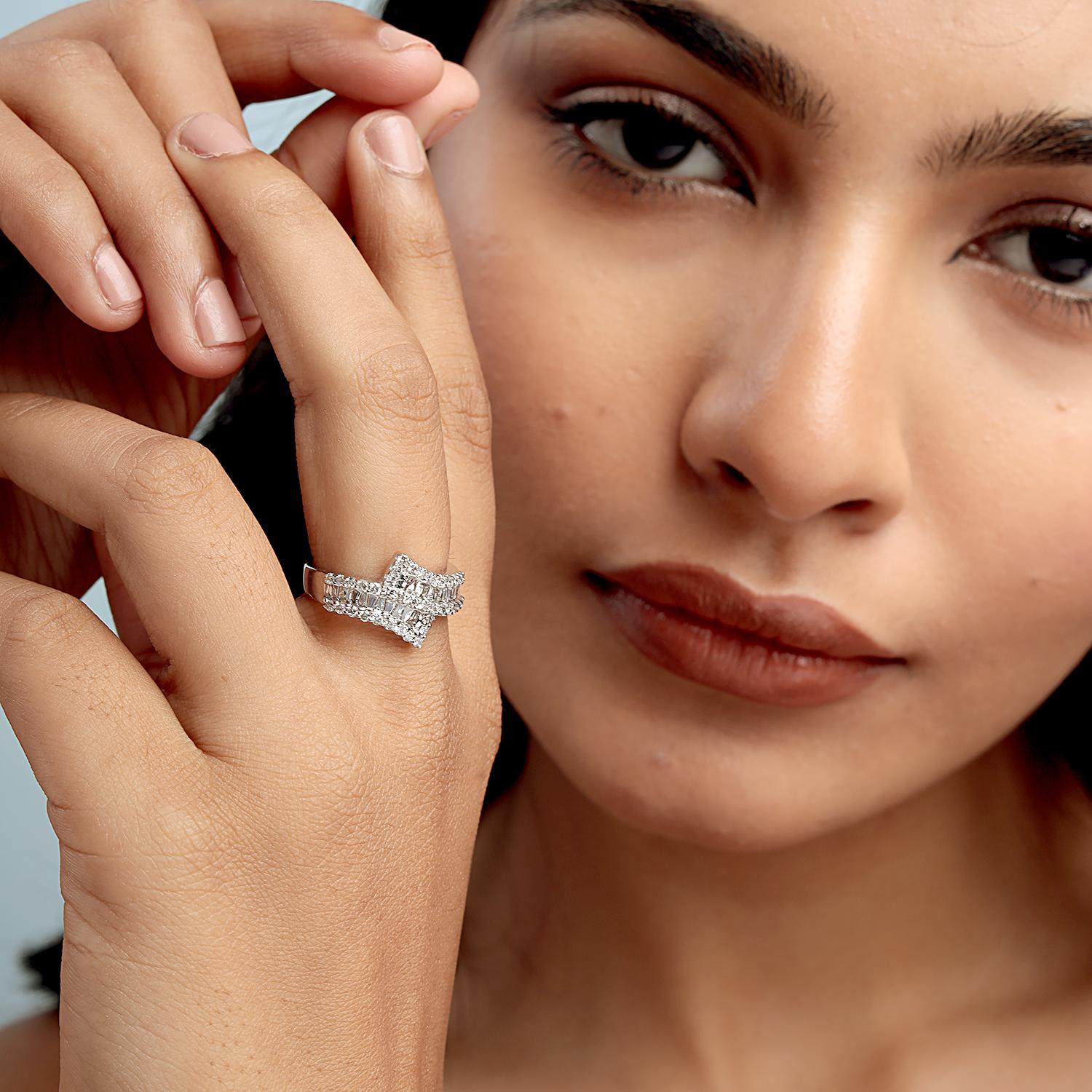 Questo splendido anello a fascia di Artisan presenta 1,10 carati di diamanti baguette e rotondi in un design dinamico e astratto a strati, realizzato con 4,750 g di oro bianco 18 carati e con dimensioni US 6,75. La sua cornice scultorea offre