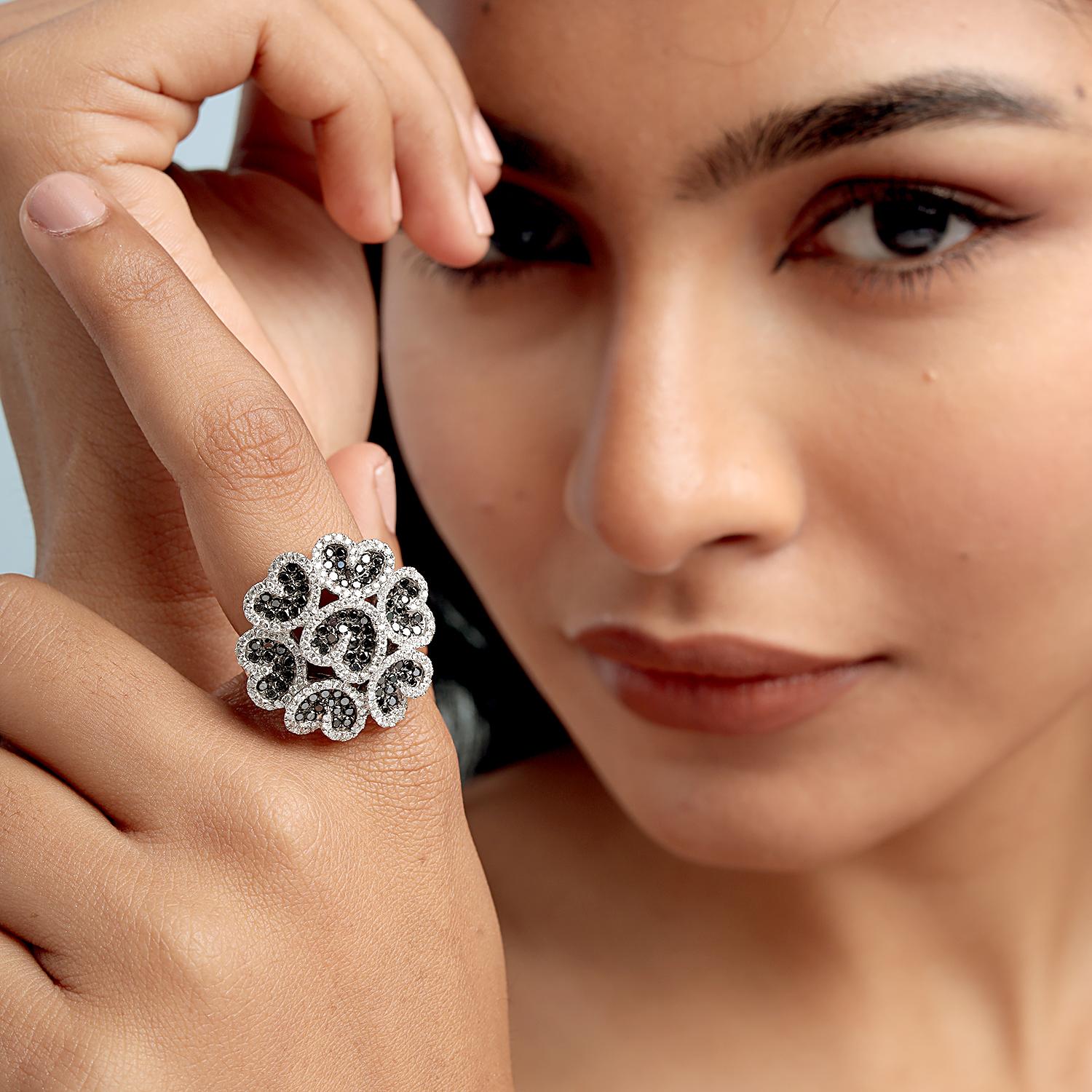 Questo audace anello da cocktail di Artisan sfoggia un ornato gruppo floreale di diamanti bianchi e neri incastonati a pavé per un totale di 2,05 carati, il tutto realizzato in 13,100 g di oro bianco 18 carati per una taglia USA 7. Il contrasto