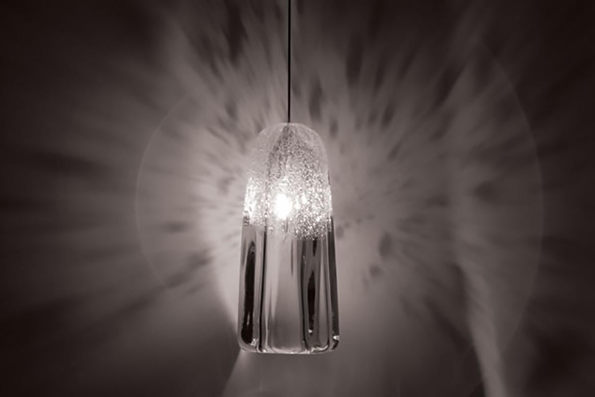 These small thick crystal pieces focus on the way glass forms and light play with each other. Whipped glass clouds the bulb and creates patterns on nearby surfaces. These low voltage fixtures can be hung singularly from a monopoint canopy or as a