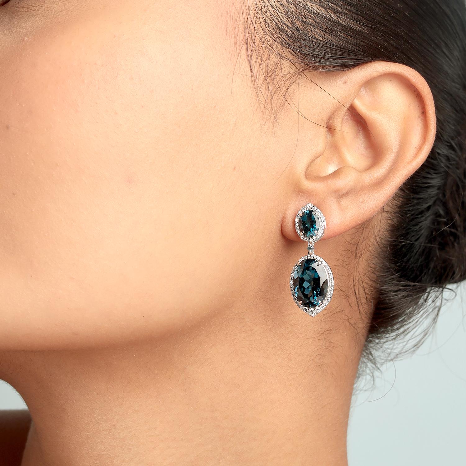 Questi orecchini a goccia di Artisan presentano 18,49 carati di topazio blu ovale circondato da 0,65 carati di diamanti scintillanti in 6,875 g di oro bianco 14K. L'elegante Silhouette da 34x13 mm, con diamanti a goccia, crea un look audace ideale