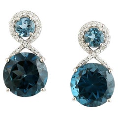 Orecchini pendenti artigianali in topazio blu con diamante in oro bianco 14 carati