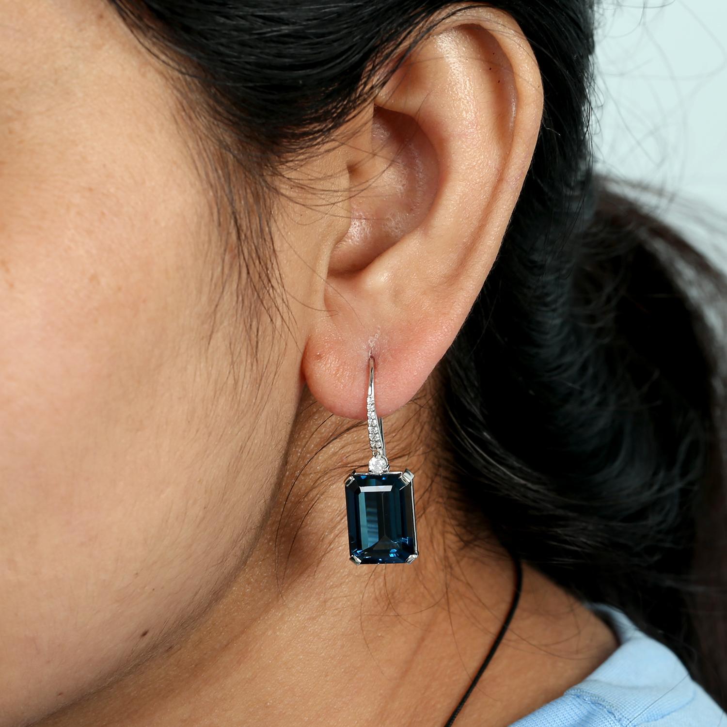 Questi moderni orecchini a goccia di Artisan presentano splendide pietre di topazio blu con taglio a smeraldo da 21,41 carati abbinate a 0,29 carati di diamanti scintillanti, il tutto incastonato in 2,676 g di oro bianco 14K. La silhouette elegante