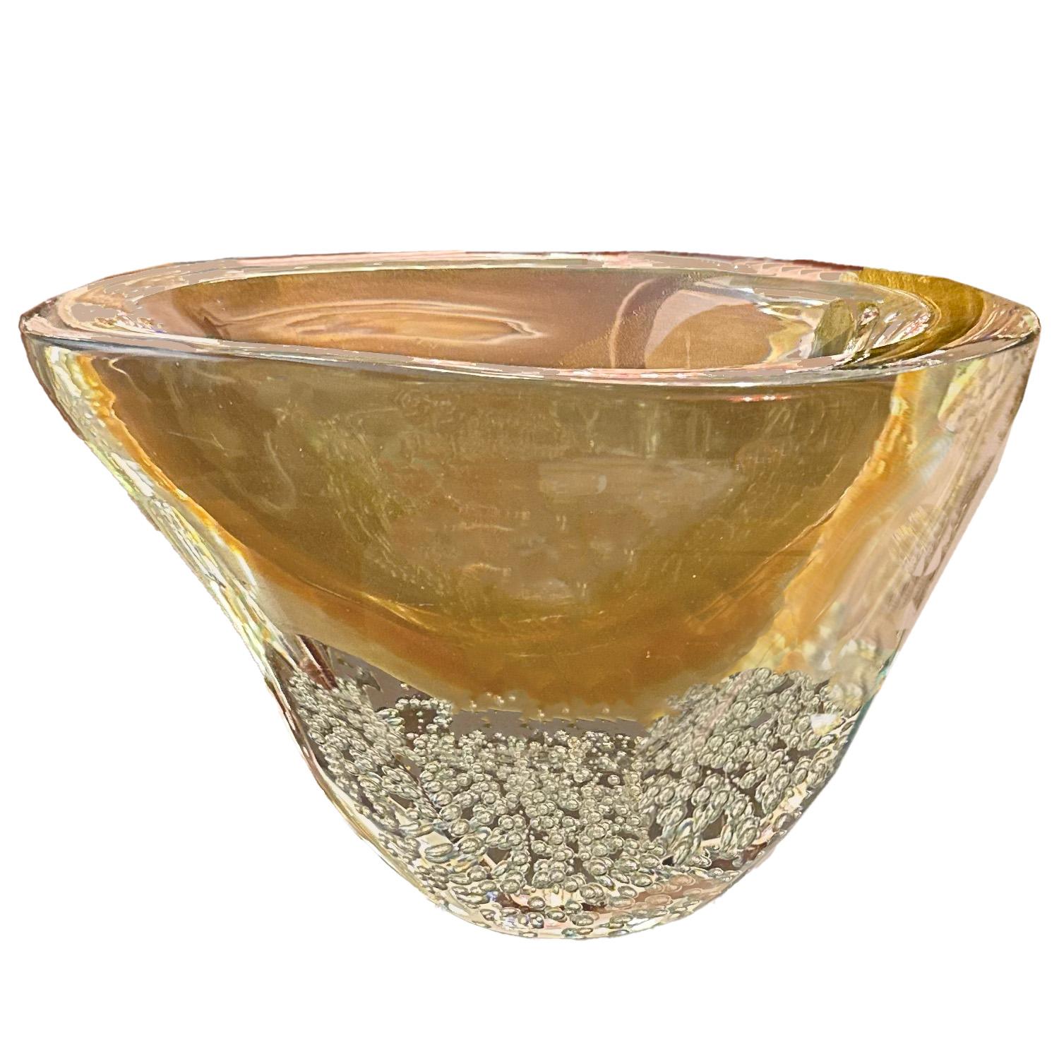 Un exquisito jarrón de cristal sommerso de Murano de color rubor y ámbar con inclusiones doradas que transita sin interrupción hacia un fondo de cristal transparente con bullicante. El degradado de color abstracto del jarrón y sus diminutas burbujas