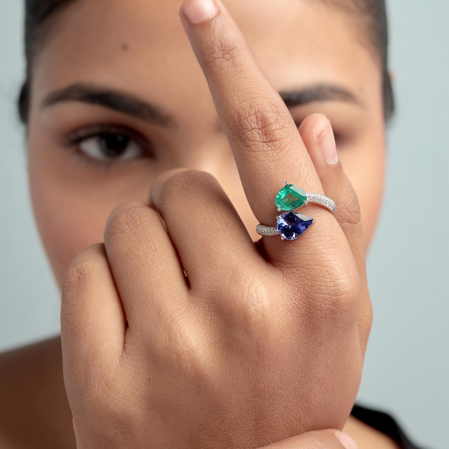 Dieser lebhafte Bypass-Ring von Artisan vereint einen Smaragd im Birnenschliff (1,45 Karat) mit einem Tansanit im Birnenschliff (1,42 Karat), akzentuiert von schimmernden Diamanten (0,23 Karat) und gefasst in 4,627 g 18 Karat Weißgold. Die offene