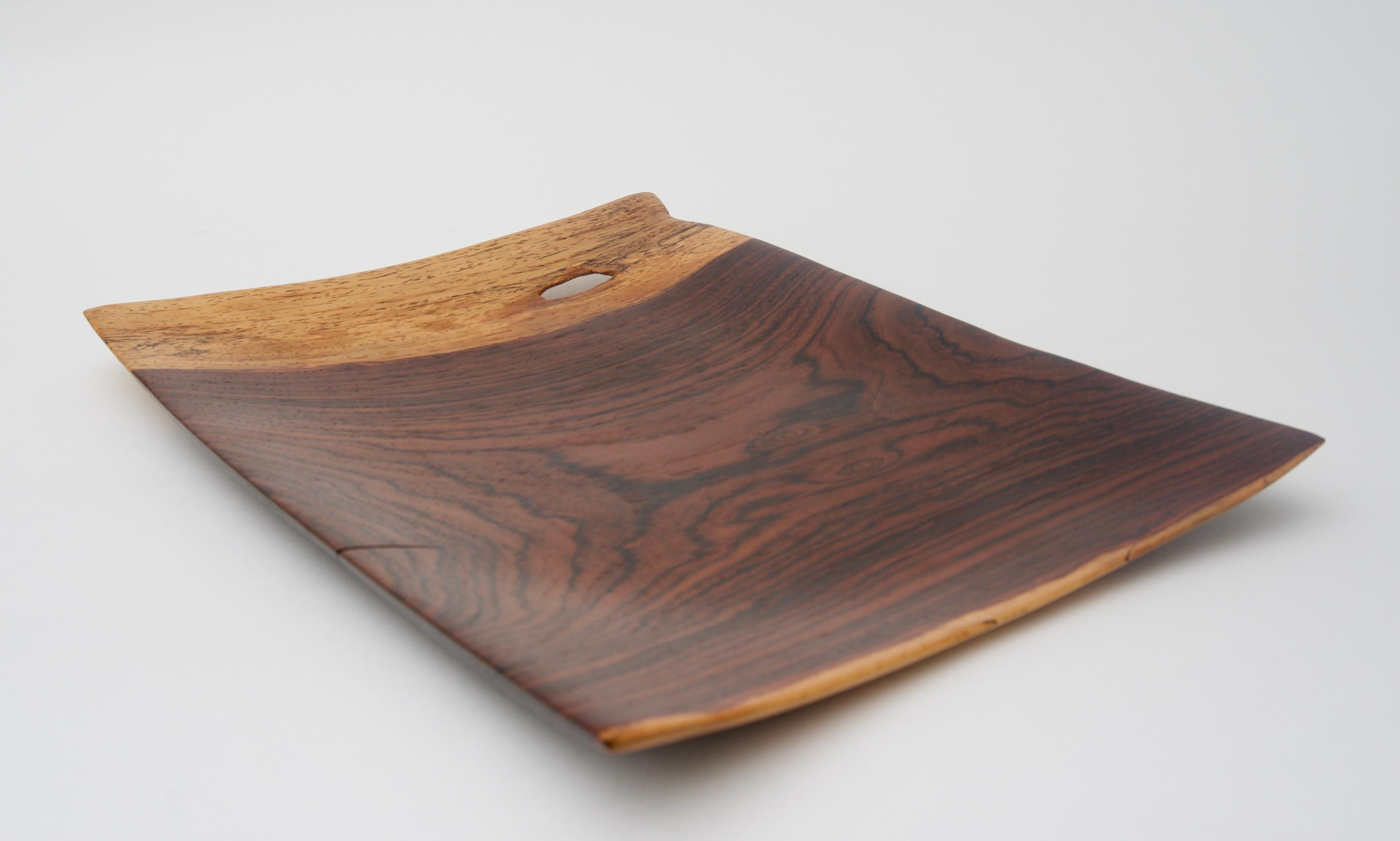 This stylish and chic organic tray is fabricated by hand in cocobolo wood and could be used to hold you keys, rings or perhaps as an hors d' ouvres plate.

FYI:
Cocobolo is a tropical hardwood of Central American trees[1] belonging to the genus