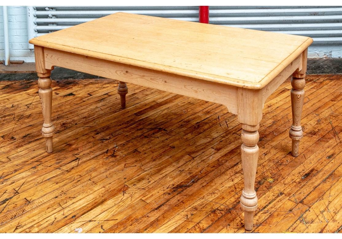 A very sturdy and solid feeling farm table. The top is an antique in a deep amber coloration affixed to the hand-crafted base which is in the more traditional Pale Pine color. Monogrammed G.W.R. The rectangular plank top with carved edges curved on