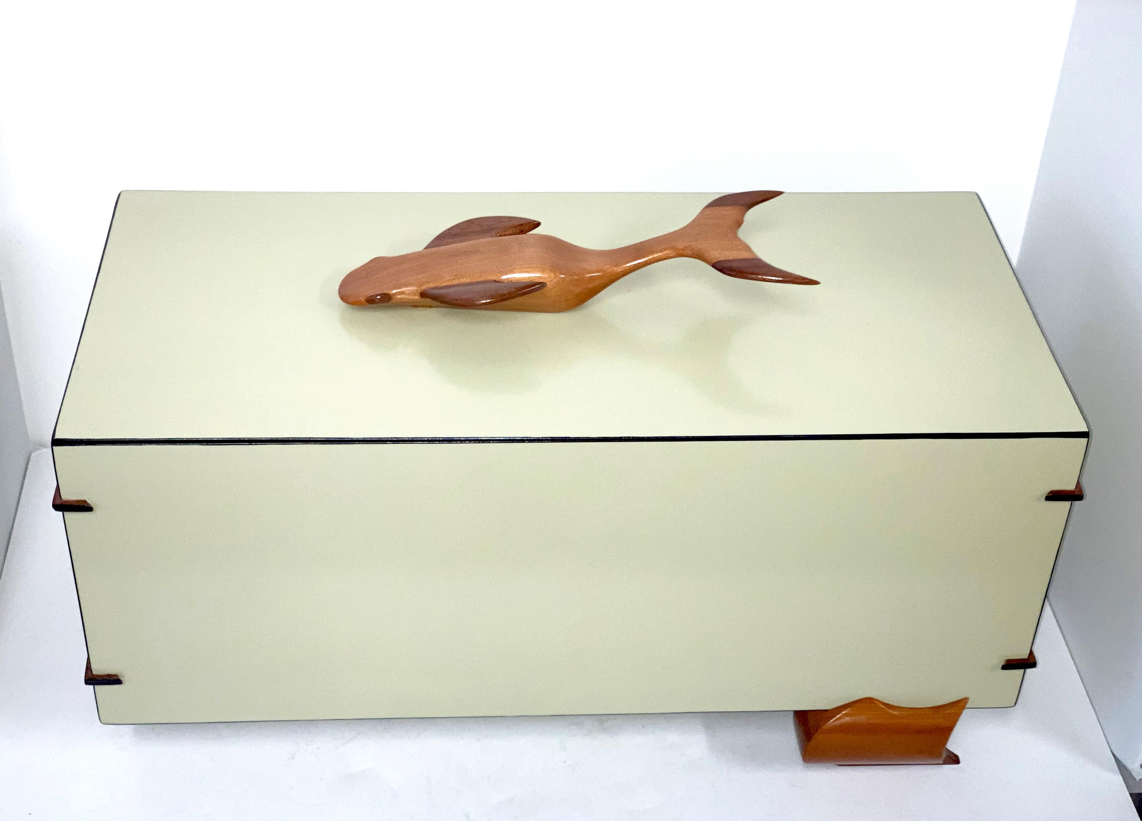 A handmade artisan box out of cherry and walnut. The artist Ken Gamet carved this elegant box and fashioned the wonderful whale top. The corners have splines and the interior is finished as well. The lid bottom features the artist's monogram. We