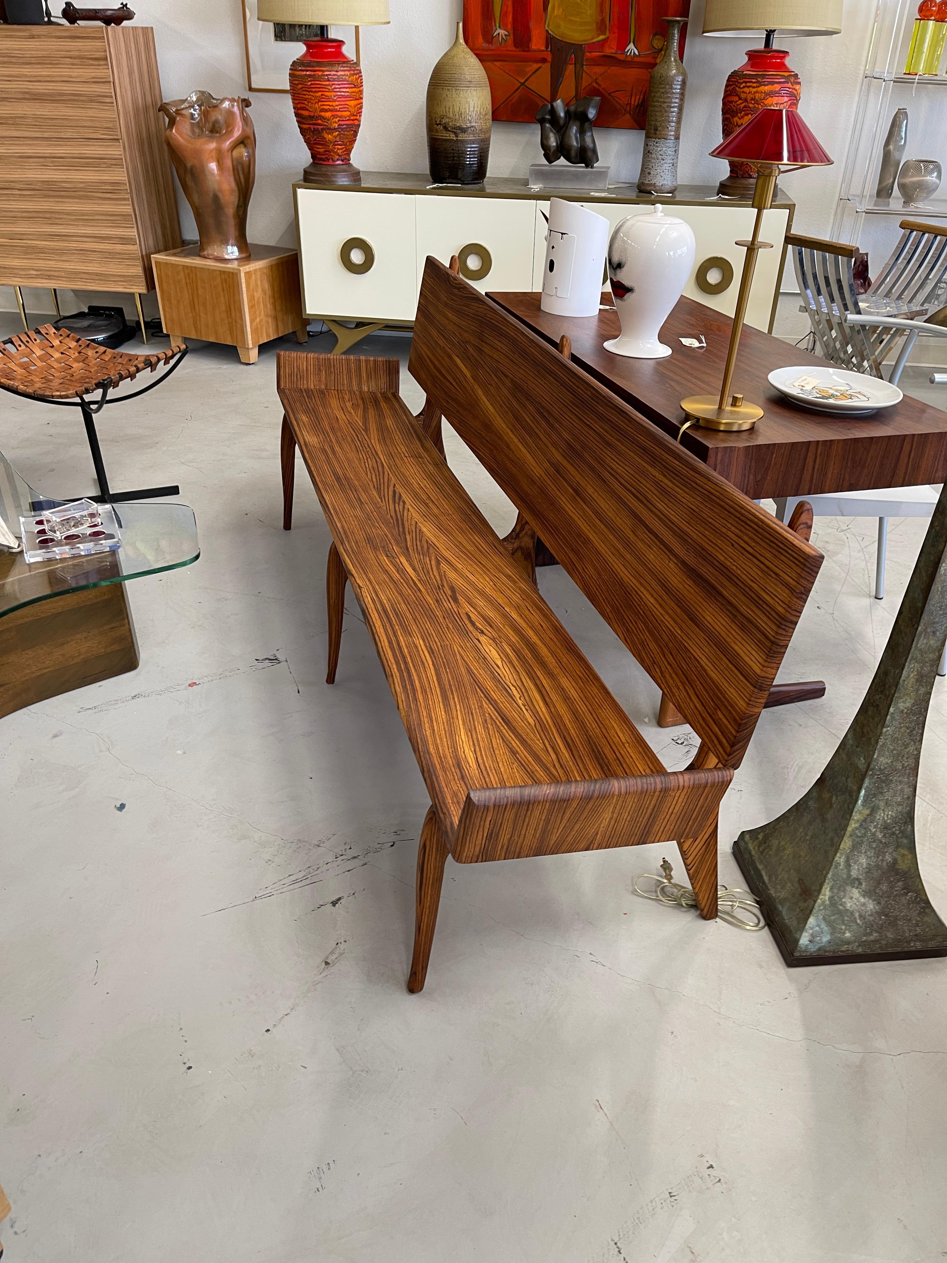 Stunning artisan craftsman solid Zebra wood bench. No veneer with all solid exotic wood bench and beautiful graining. Nice styling with elegant lines. The bench has been re-glued and tightened. Likely late 20th century. The center bottom support is