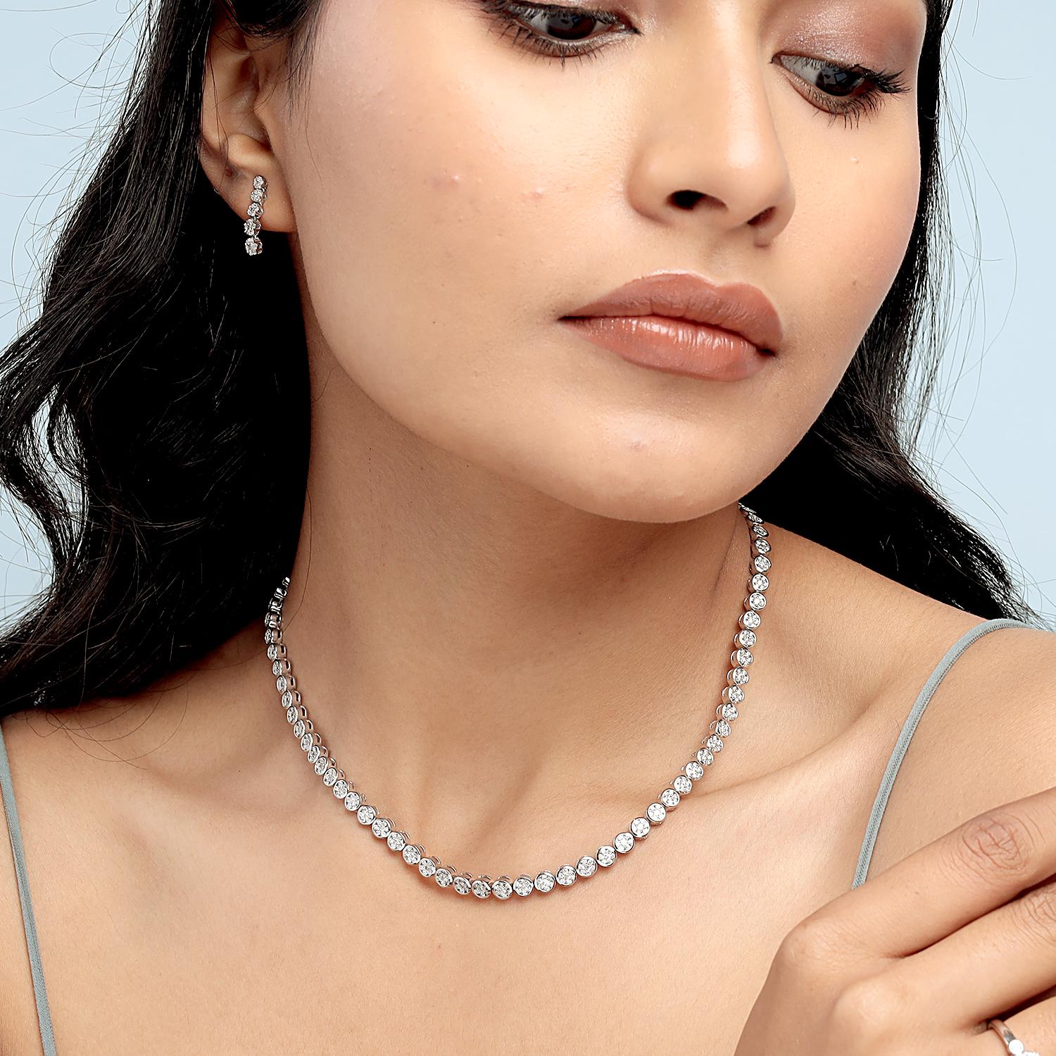 Questa splendida collana tennis di Artisan presenta 8,15 carati di diamanti tondi brillanti, ciascuno incastonato in un elegante castone e realizzato in 32,736 g di oro bianco 18 carati. Con una misura di 419 mm, la sua silhouette classica offre una