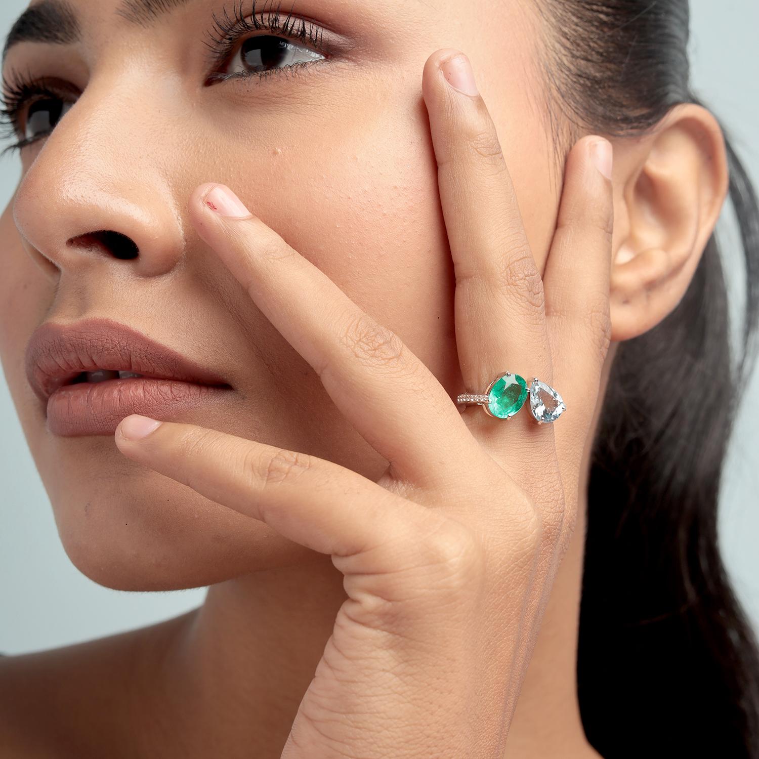 Questo elegante anello bypass di Artisan presenta uno smeraldo ovale da 1,84 carati e un'acquamarina da 1,27 carati con taglio a pera, rifiniti con 0,10 carati di diamanti scintillanti su una fascia in oro bianco 18 carati da 4,862 grammi. Il design