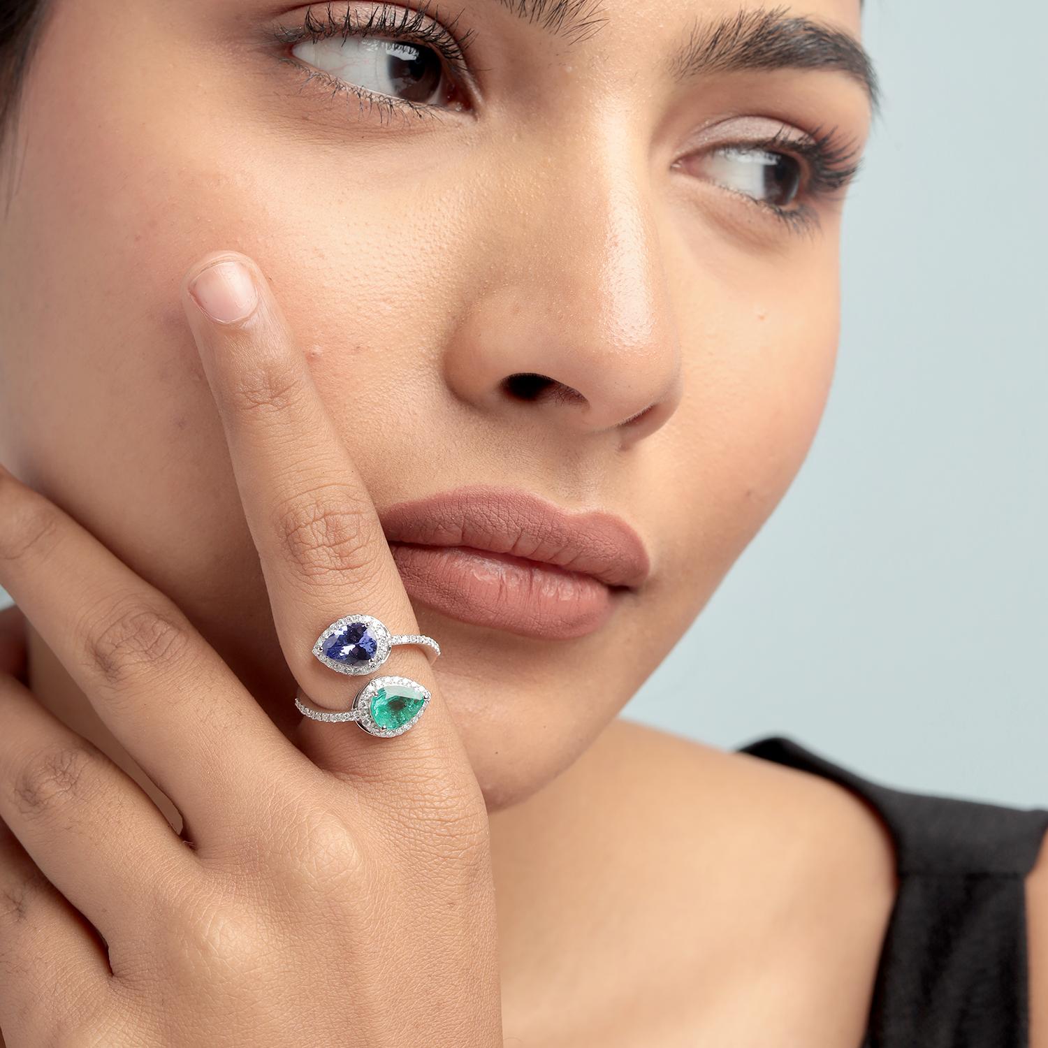 Dieser elegante Bypass-Ring von Artisan zeigt einen lebhaften Smaragd im Birnenschliff von 1,00 Karat und einen Tansanit im Birnenschliff von 1,05 Karat, beide umgeben von 0,45 Karat Brillanten, alle gefasst in 3,885 g 18 Karat Weißgold. Das offene,