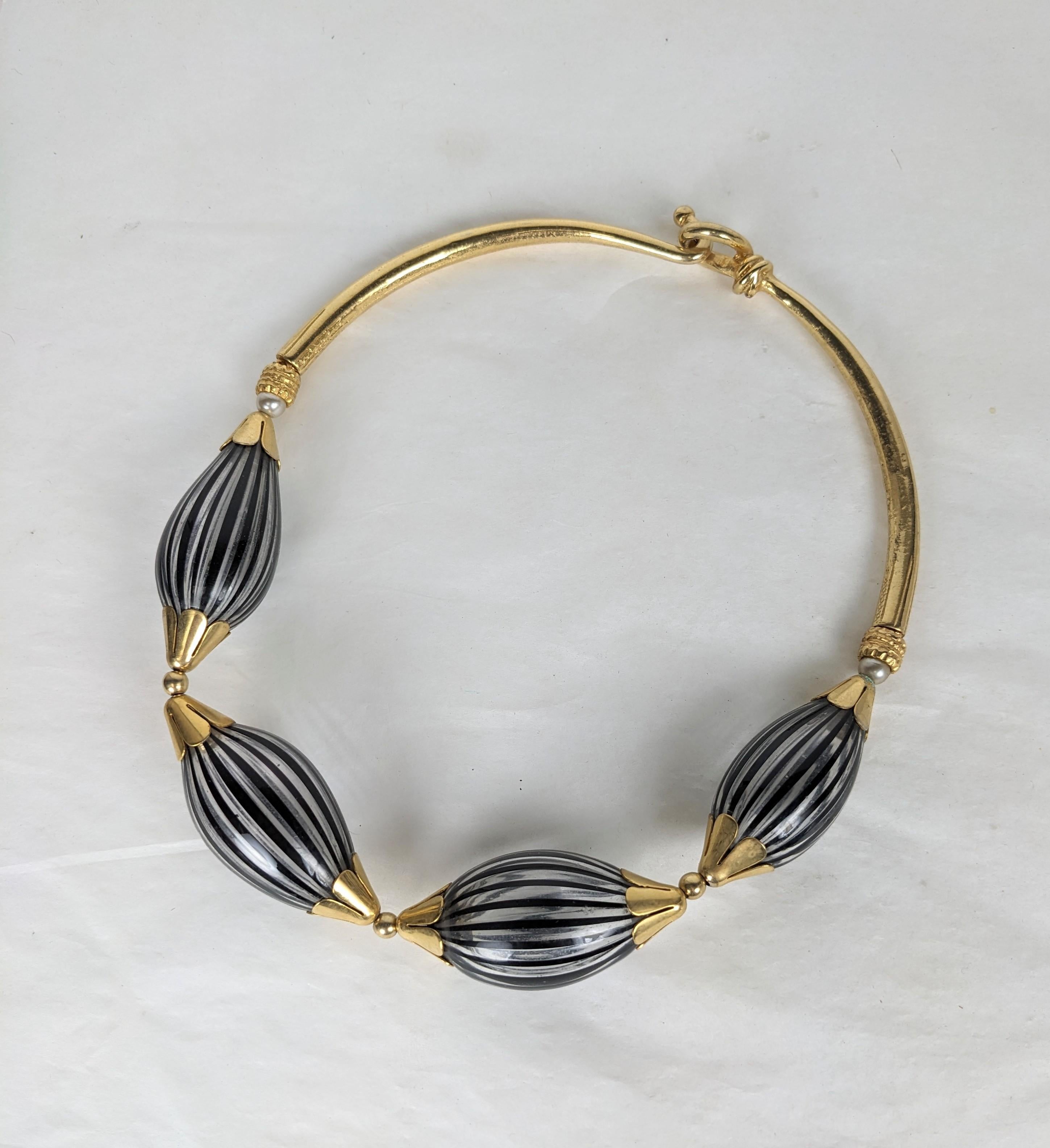 Außergewöhnliche handwerkliche französische Halskette mit venezianischen Glasperlen aus den 1980er Jahren. Große mundgeblasene Glasperlen mit schwarzen und weißen Streifen enden in vergoldeten Blumenkappen und einem harten Halsbandverschluss auf der
